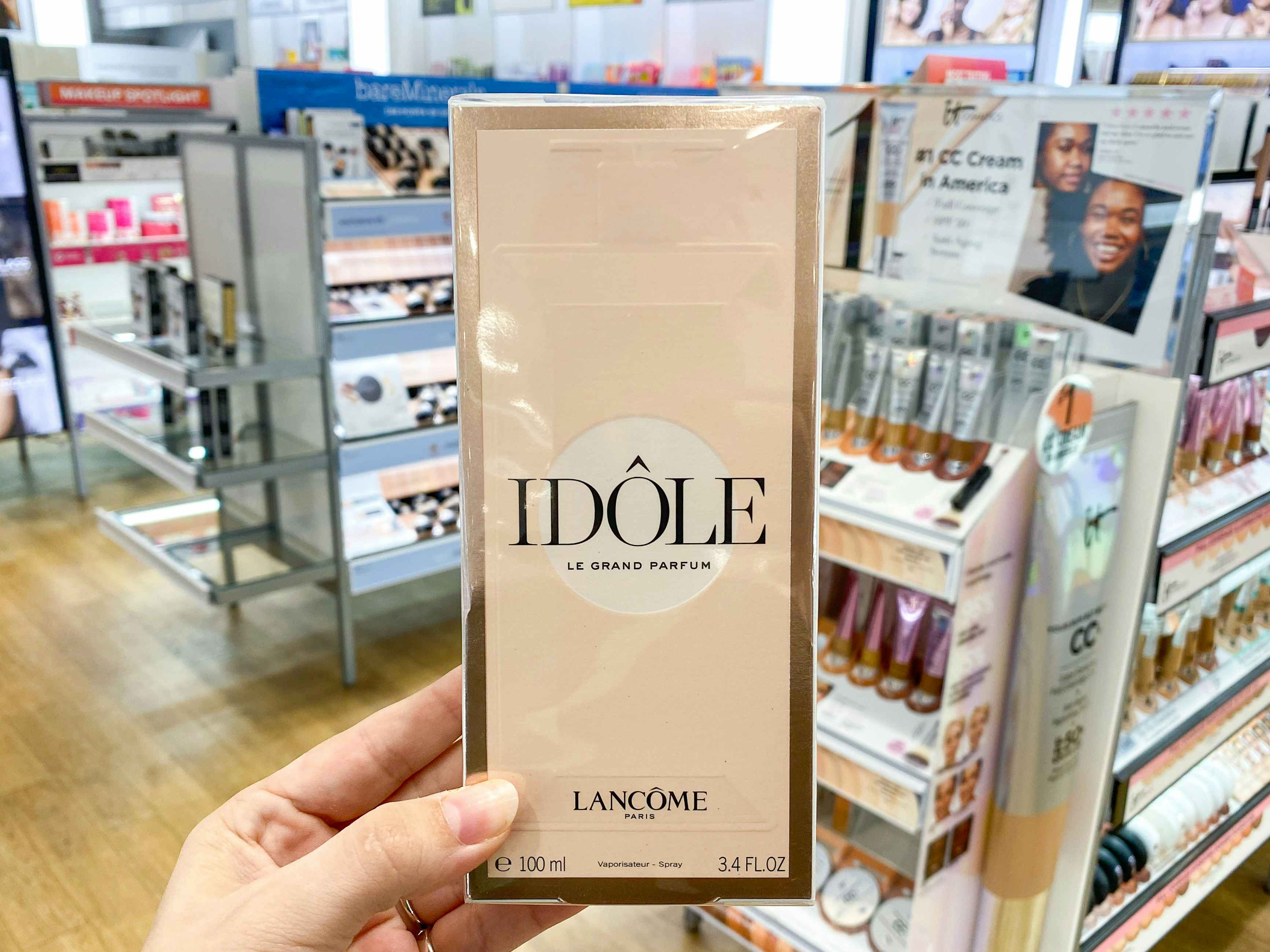 a person holding up idole perfume in ulta 