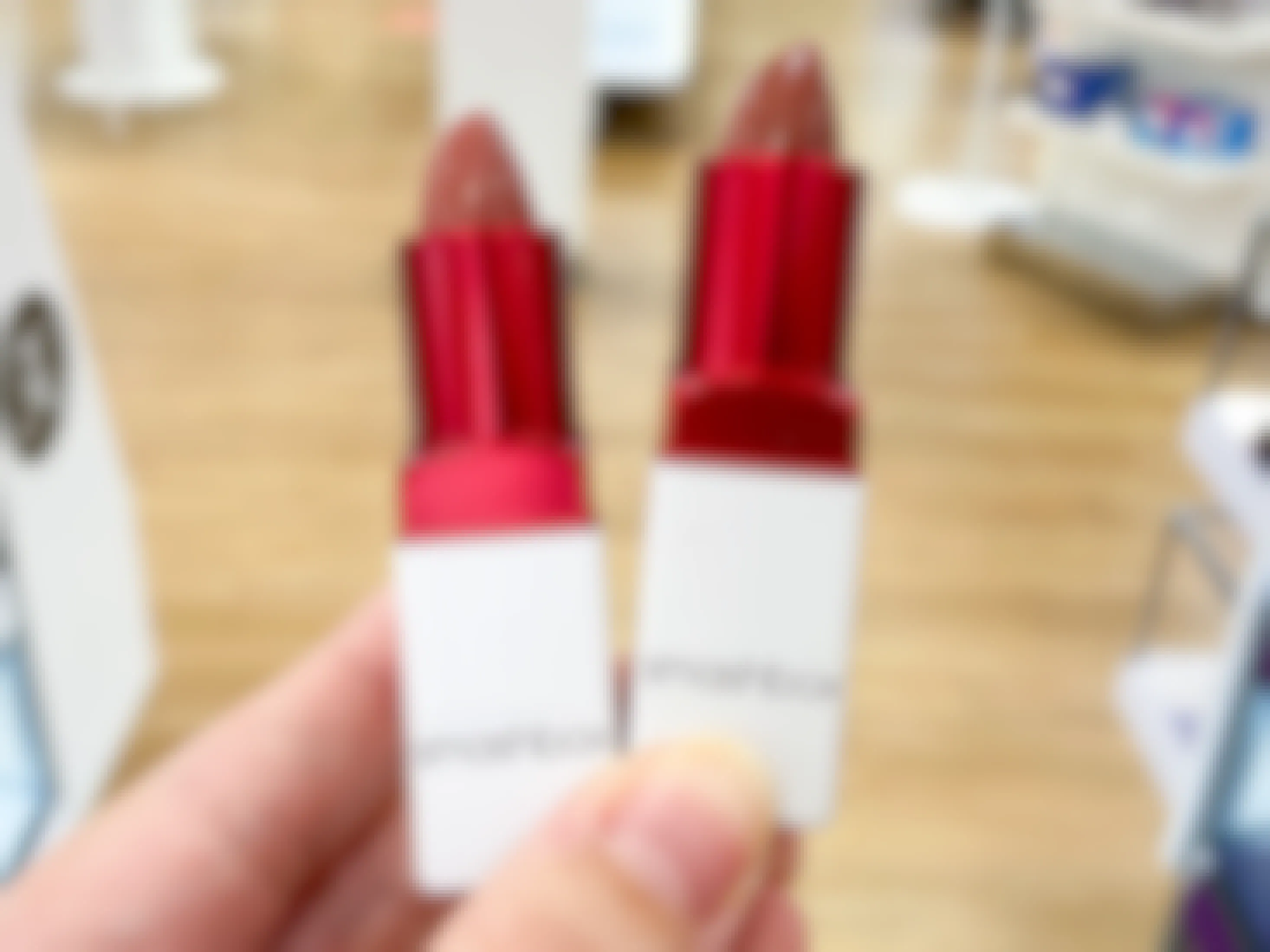 person holding two smashbox prime plush lipsticks in ulta store