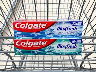 Two boxes of Colgate MaxFresh toothpaste stacked in a Walgreens shopping cart basket.
