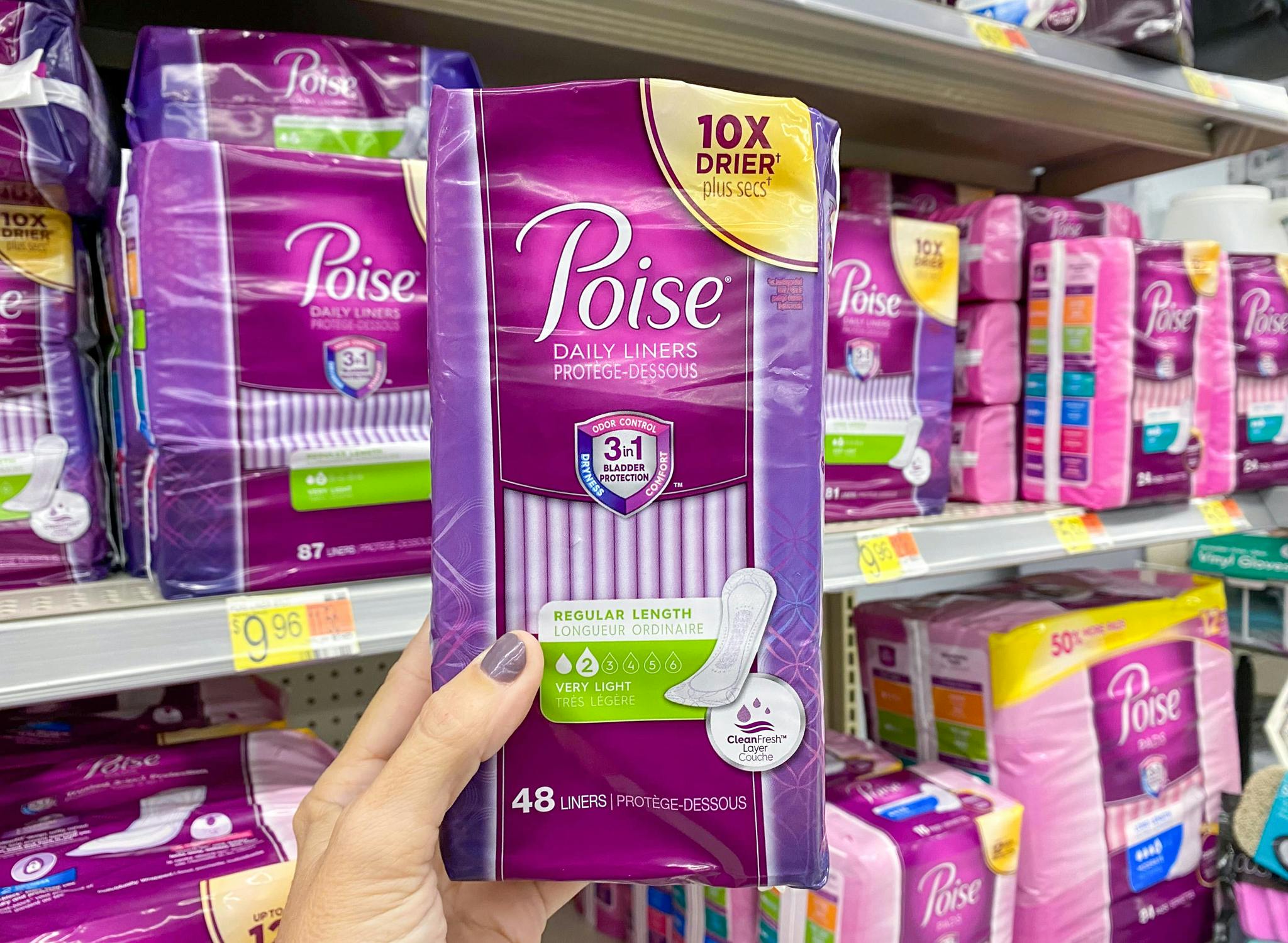 Holding up a pack of Poisedaily liners in front of a shelf stacked with other Poise products at Walmart