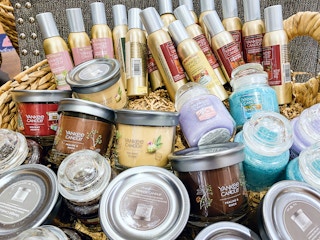 basket of yankee candle room spray and single- and three-wick candles in store