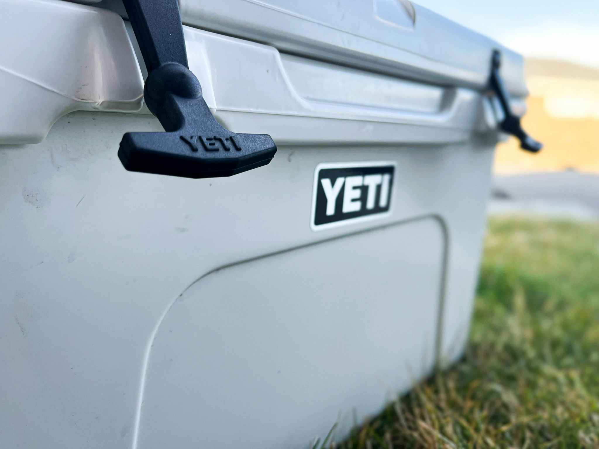 A close up of a YETI cooler sitting on the grass.