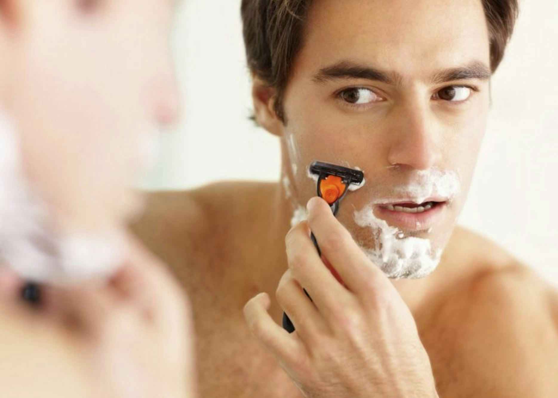 A man shaving his face with a Bic razor.