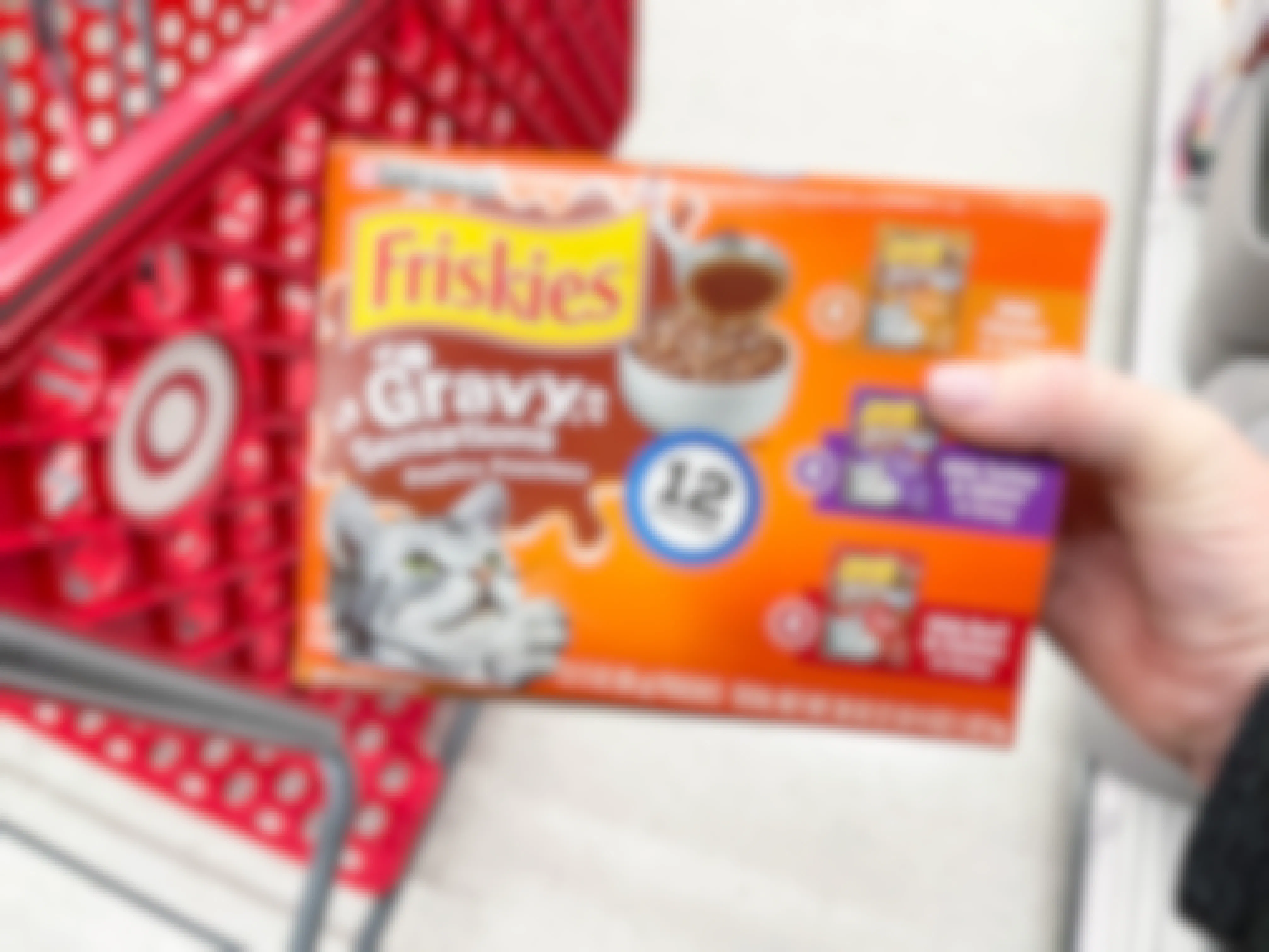 a box of Friskies wet cat food being held in front of target cart