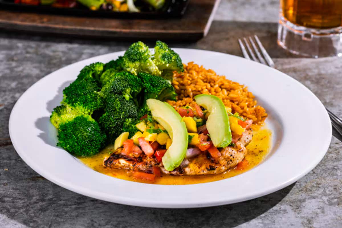 A plate of Chili's Mango-Chile Chicken with broccoli from their guiltless grill menu.