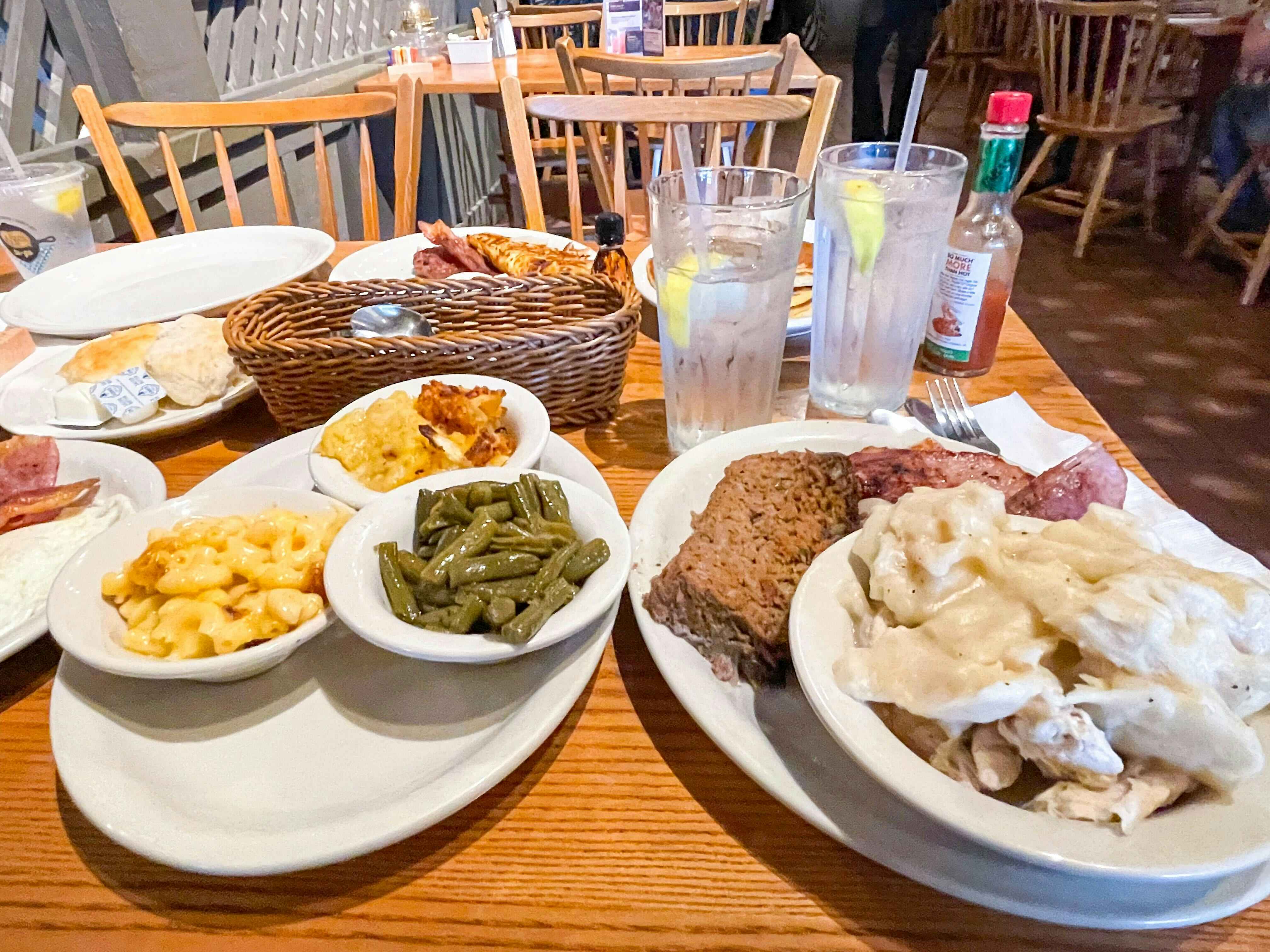 A table at Cracker Barrel covered with plates of different foods from the menu.