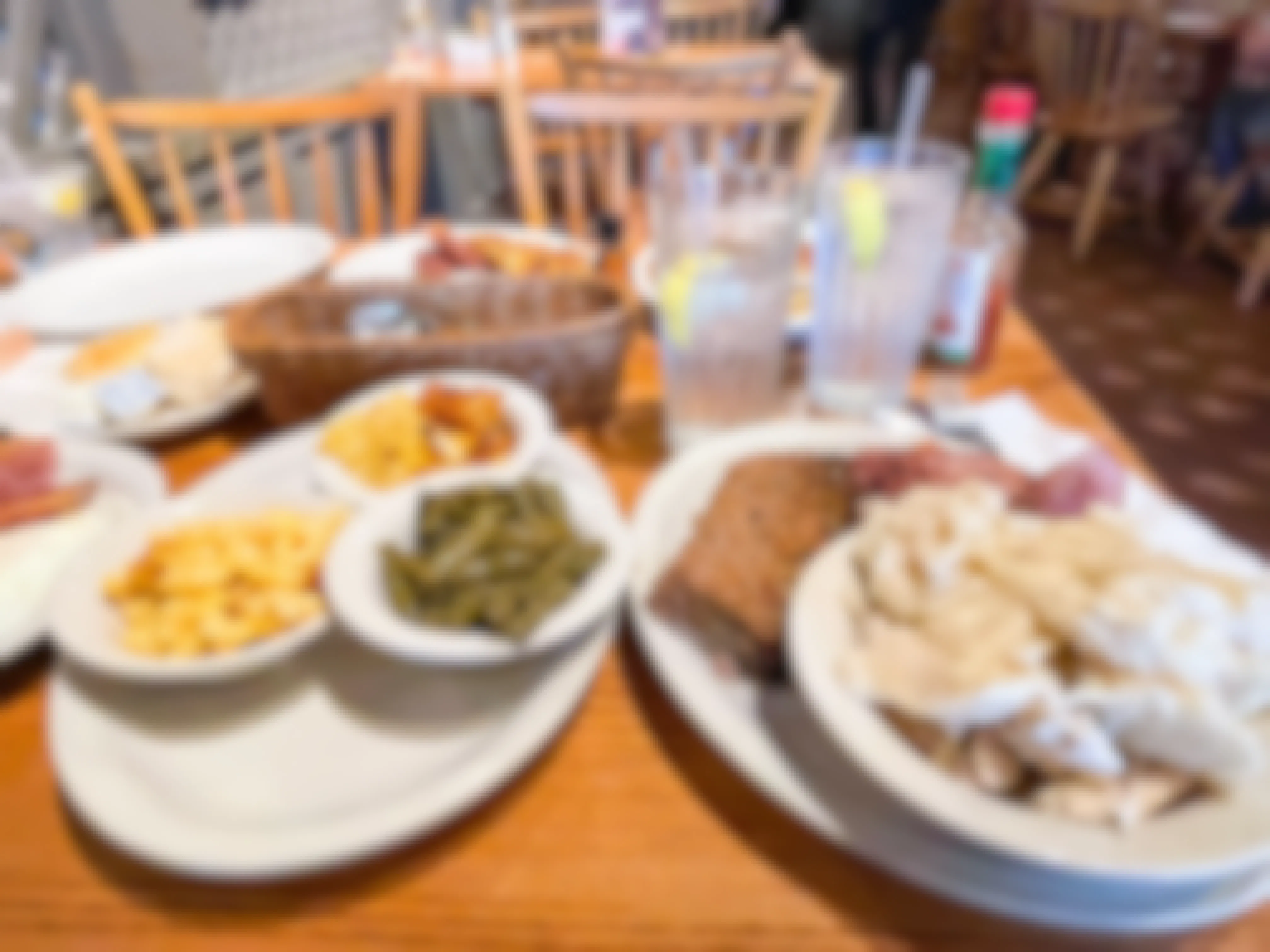 A table at Cracker Barrel covered with plates of different foods from the menu.