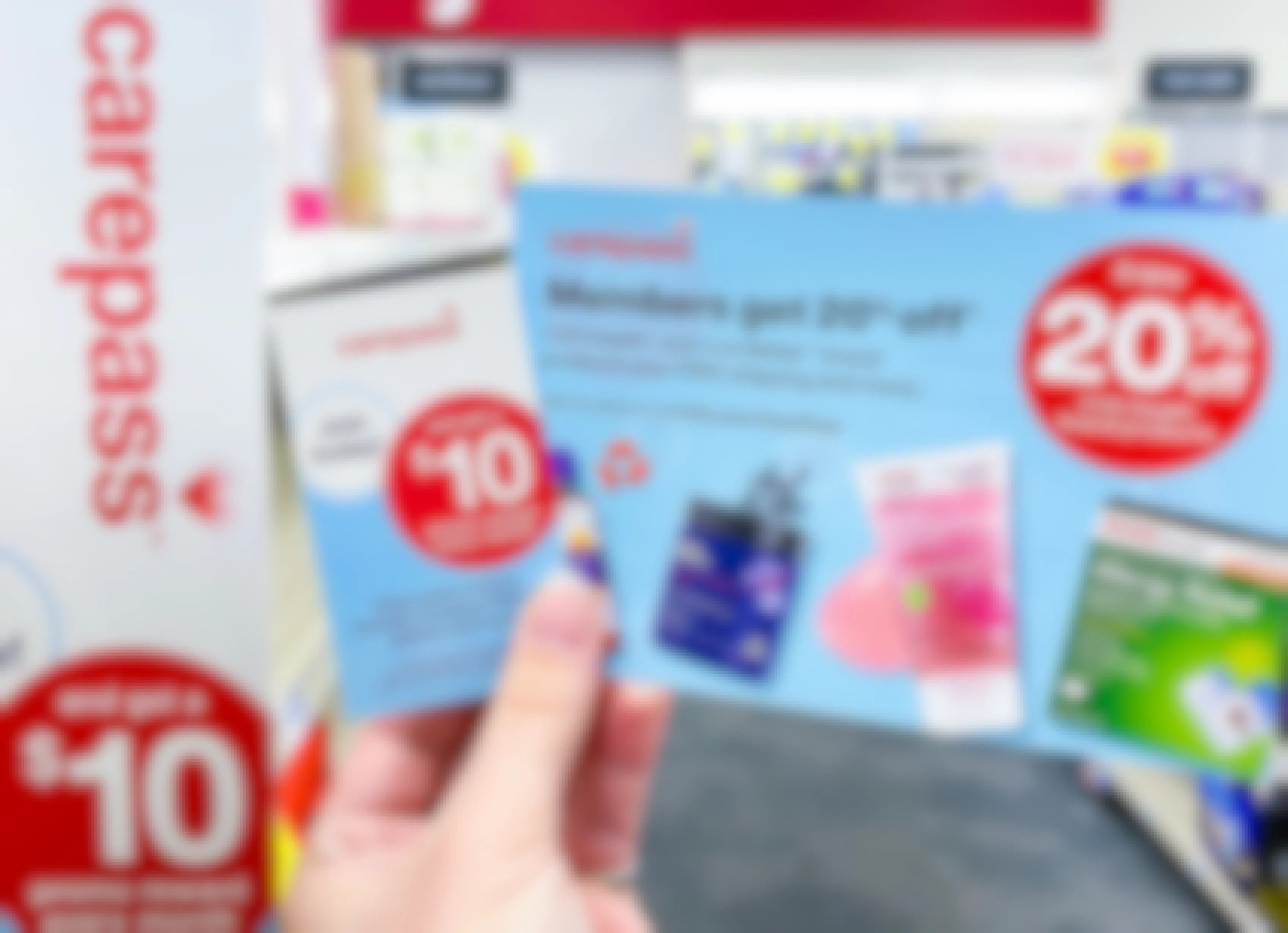 Someone holding some CVS Carepass information cards in a CVS