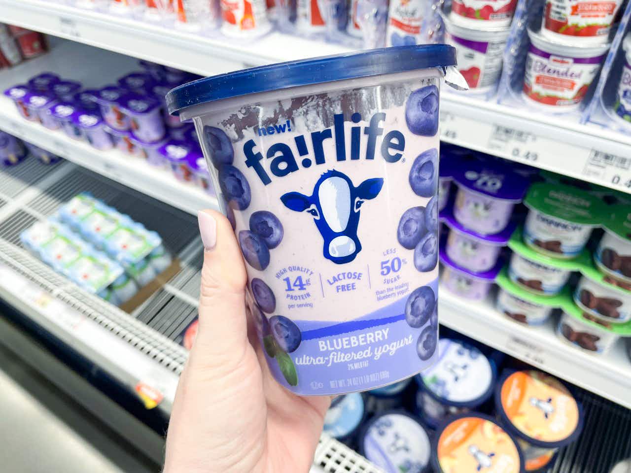 a person holding up fairlife yogurt