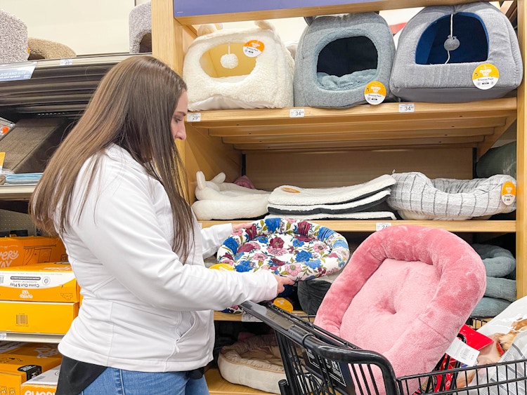 a woman putting cat beds in cart in petco