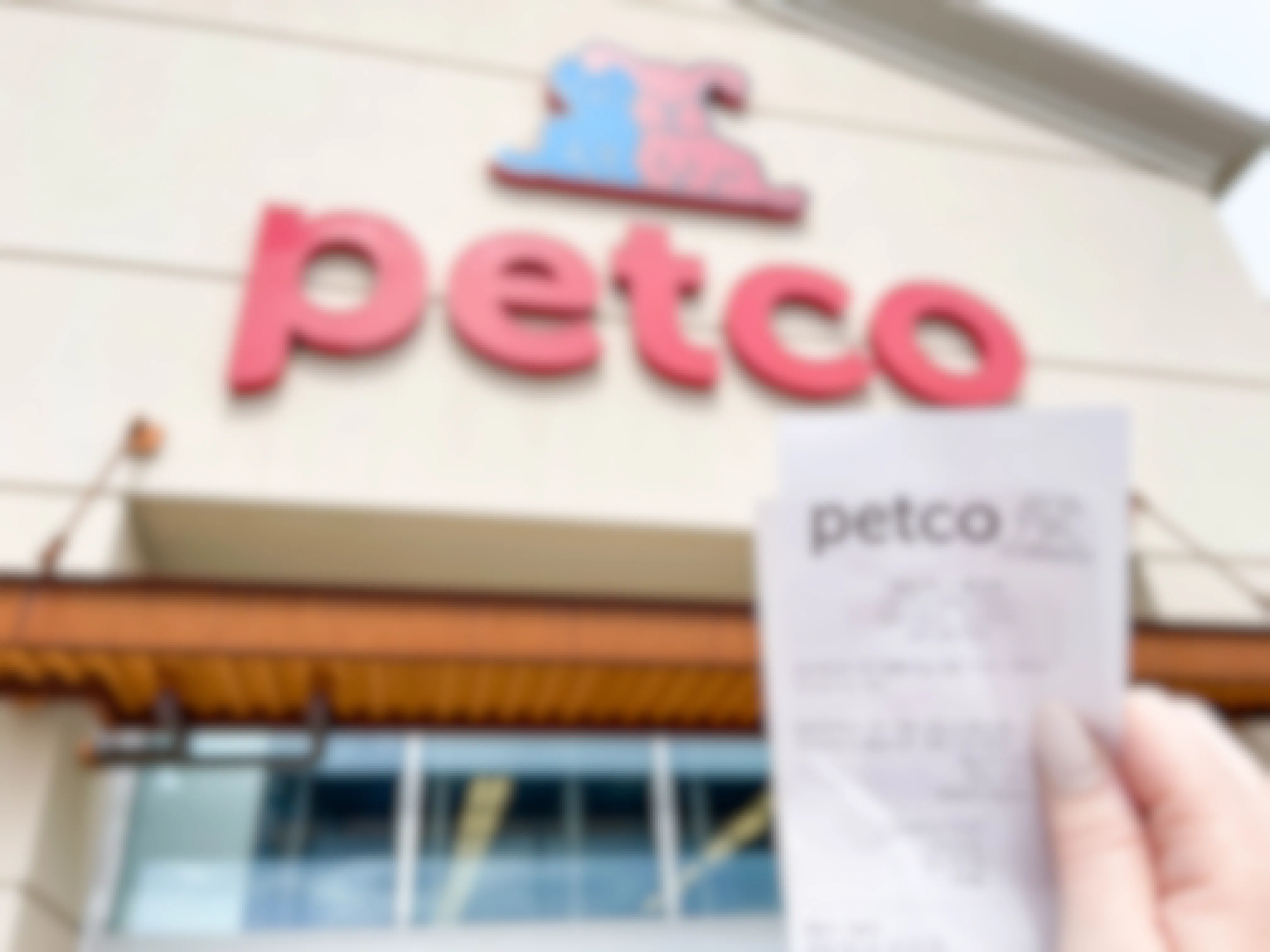 a person holding up at petco receipt outside of petco
