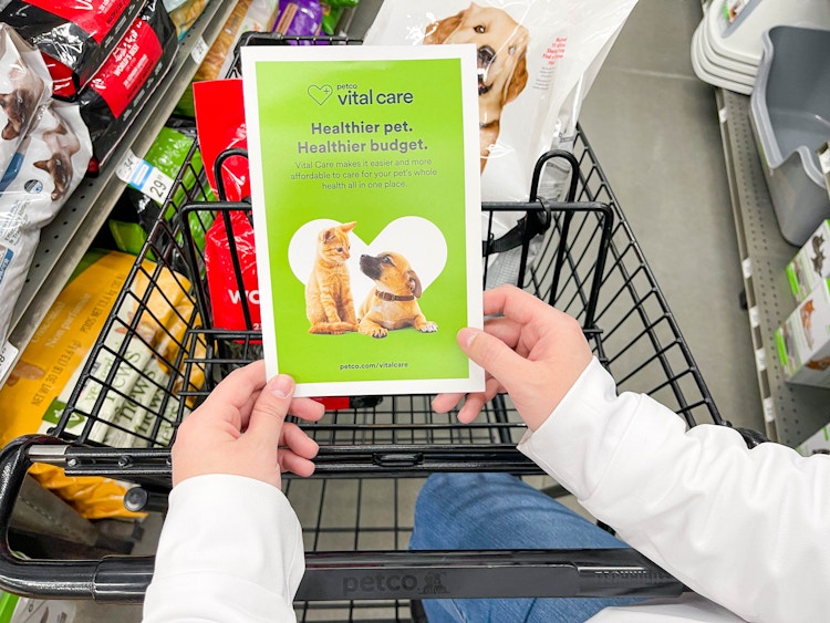 a person at at shopping cart looking at a brochure in store for petco vital care