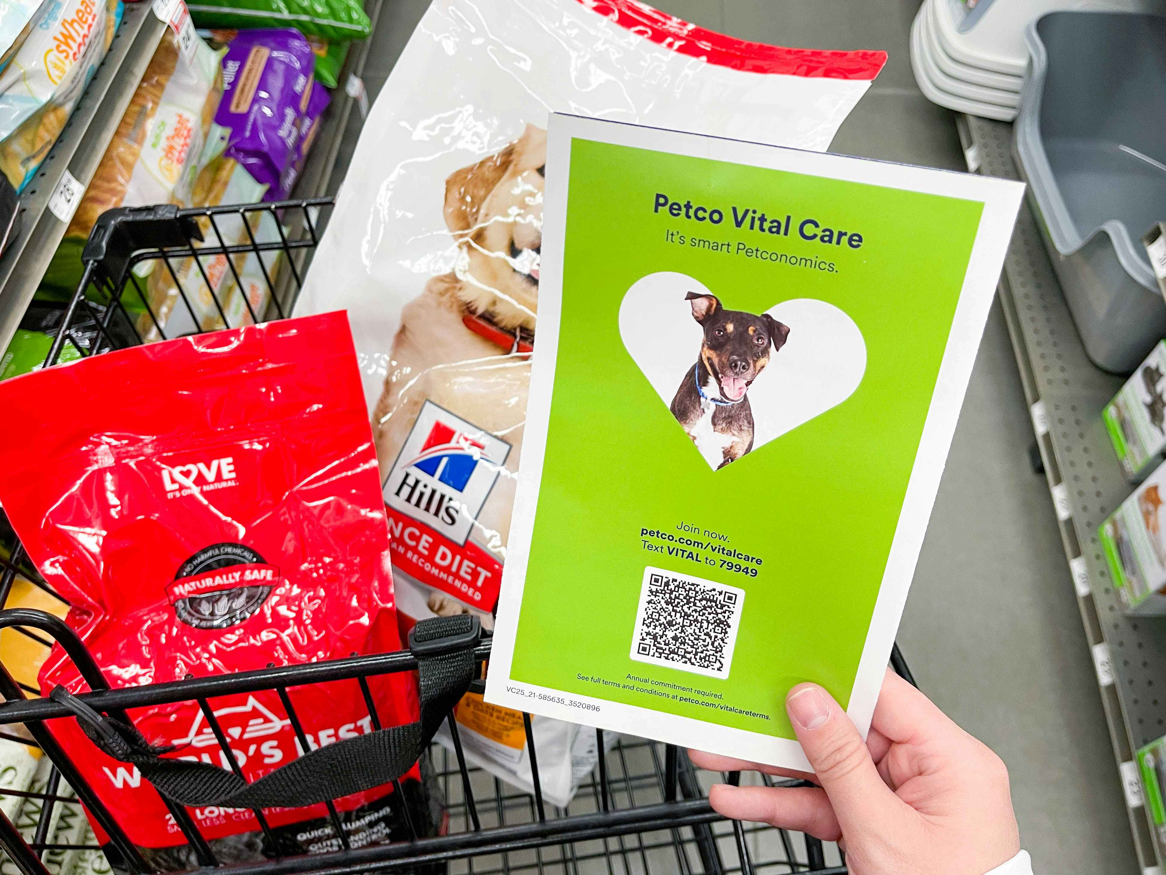 a person at at shopping cart looking at a brochure in store for petco vital care 