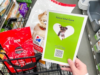 a person at at shopping cart looking at a brochure in store for petco vital care
