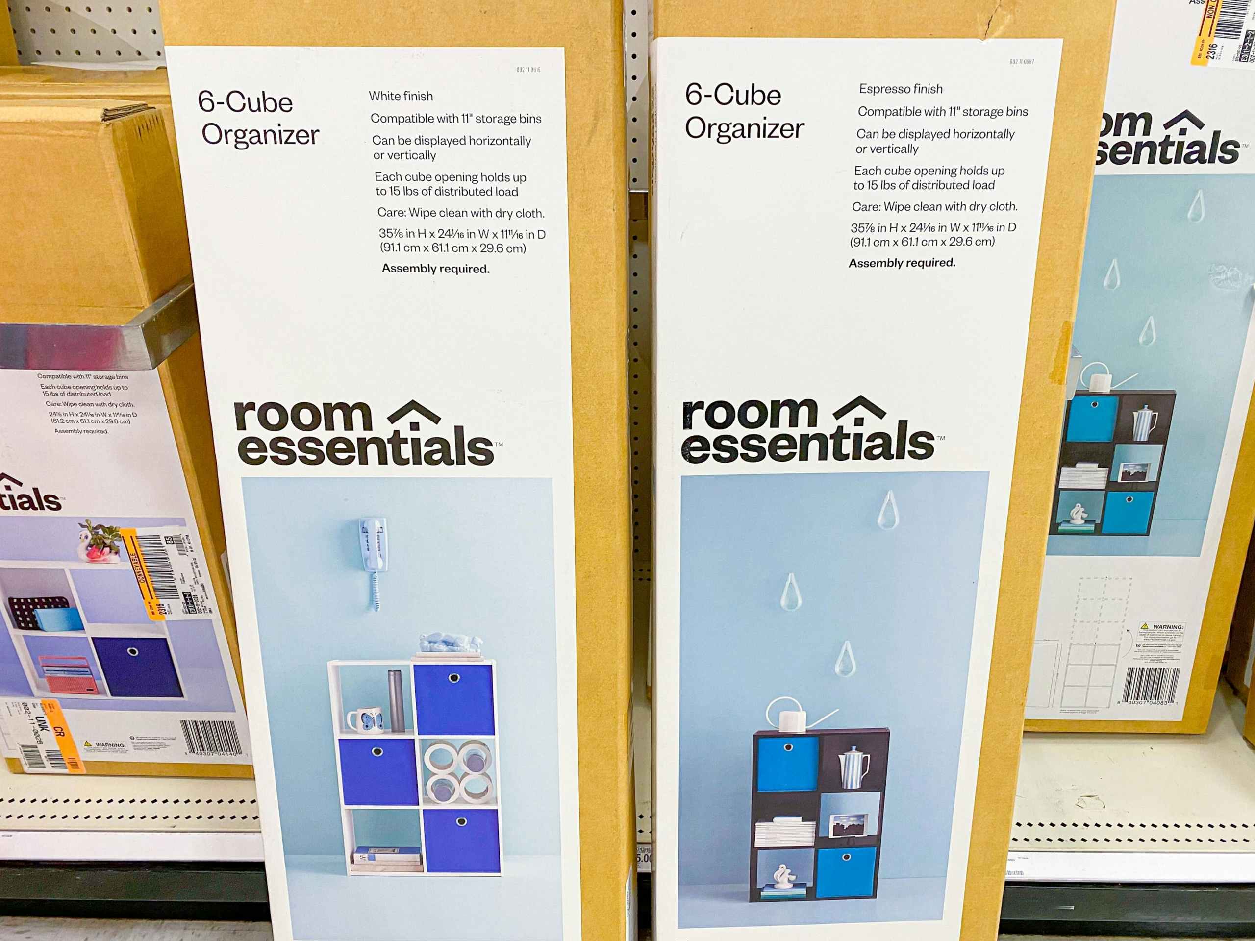 Two boxes for Room Essentials 6-Cube Organizers on the floor in front of the shelf at Target.