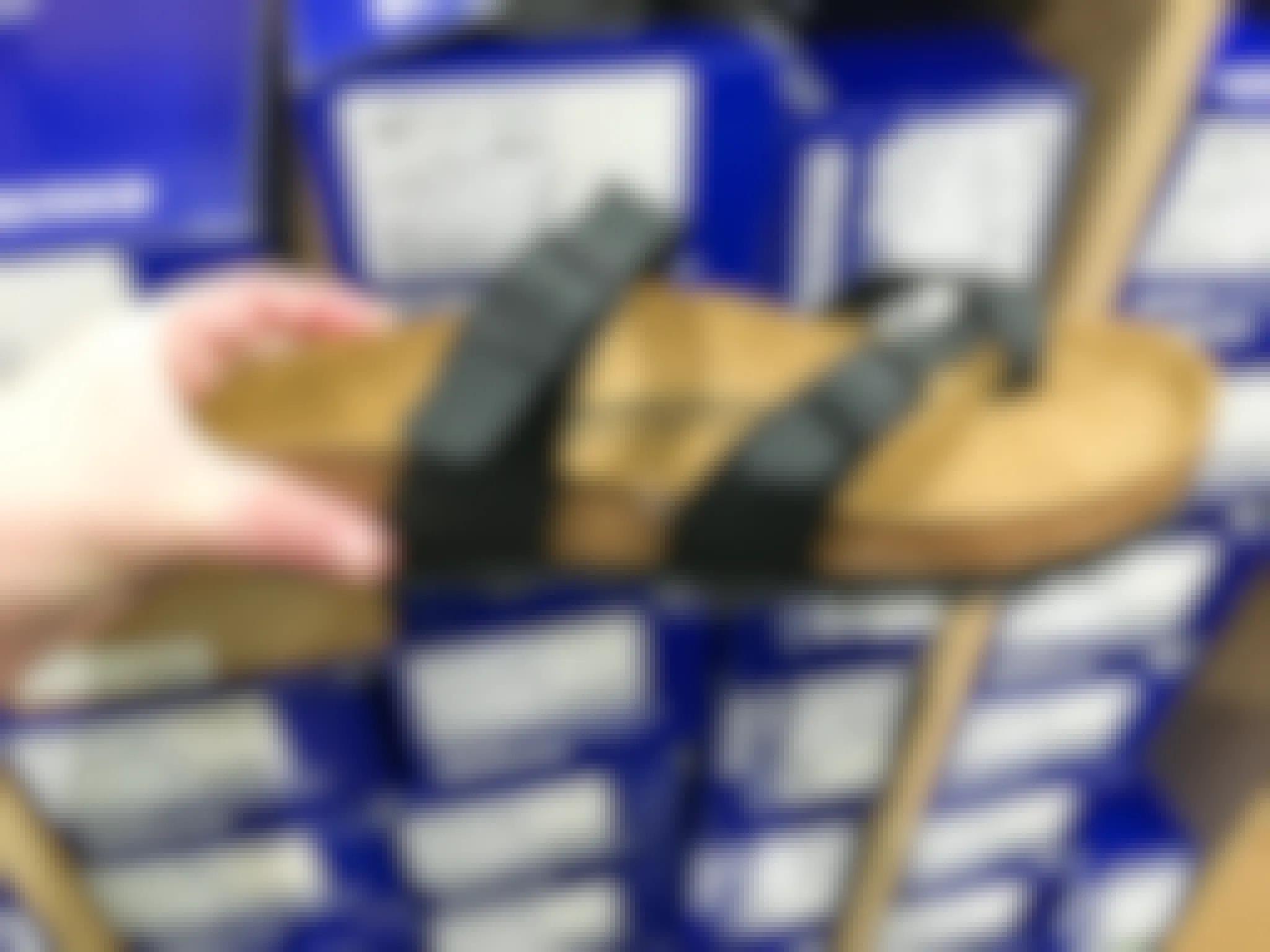 A person's hand holding a Birkenstock sandal in front of Birkenstock shoeboxes.