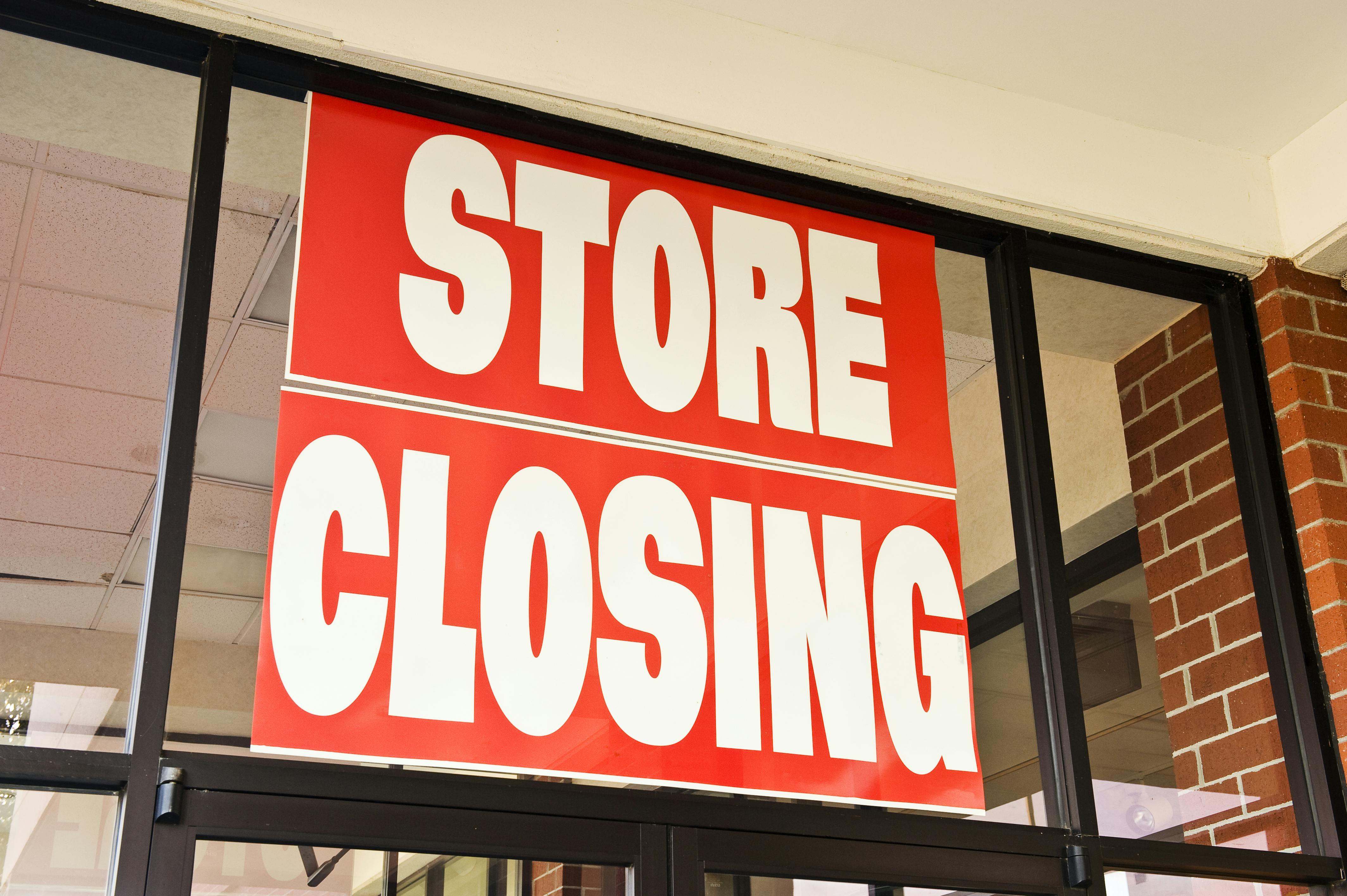 A store closing sign on a window