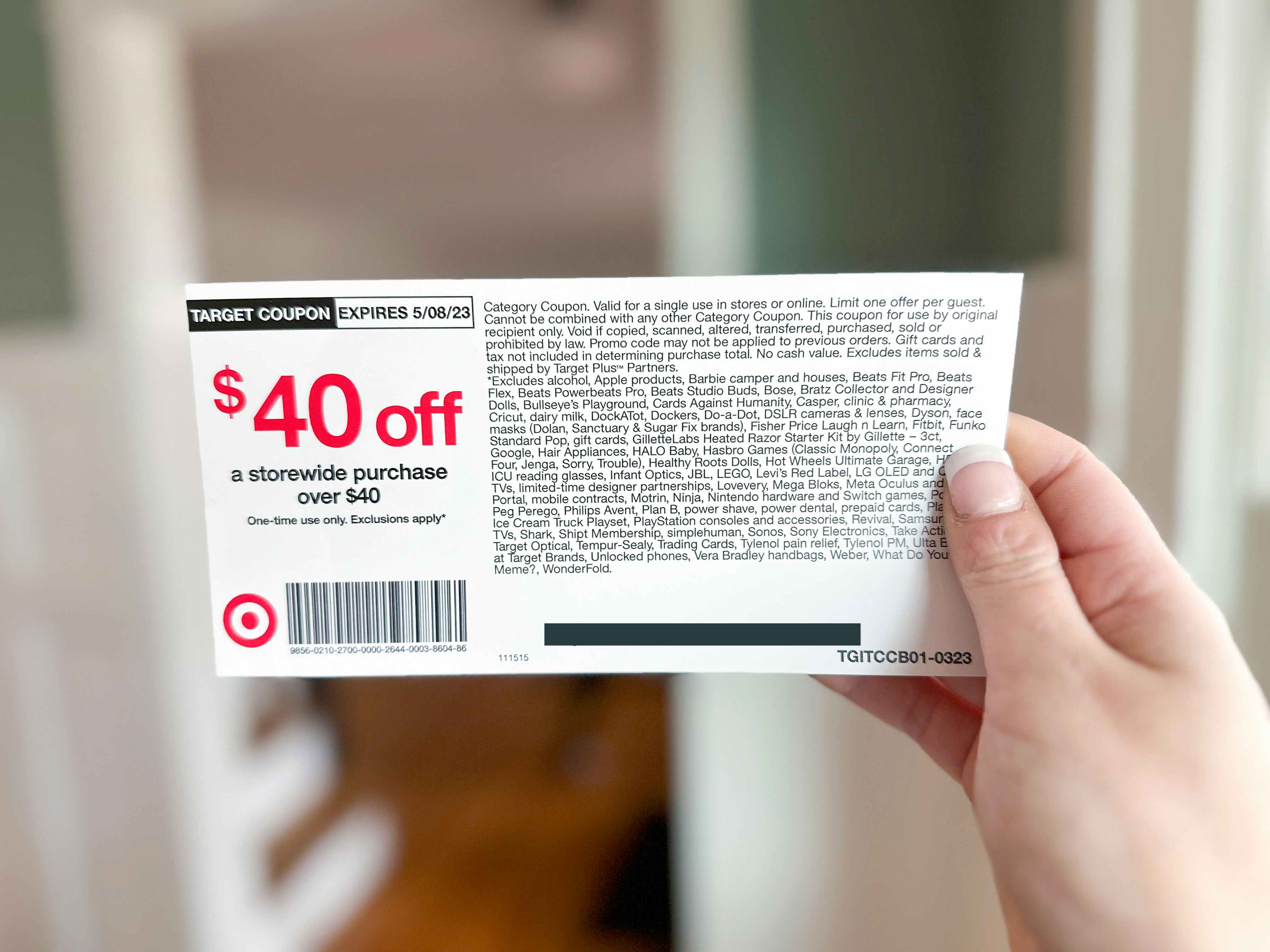 A woman's hand holding up a $40 off coupon from the limited-time Target RedCard offer for new members