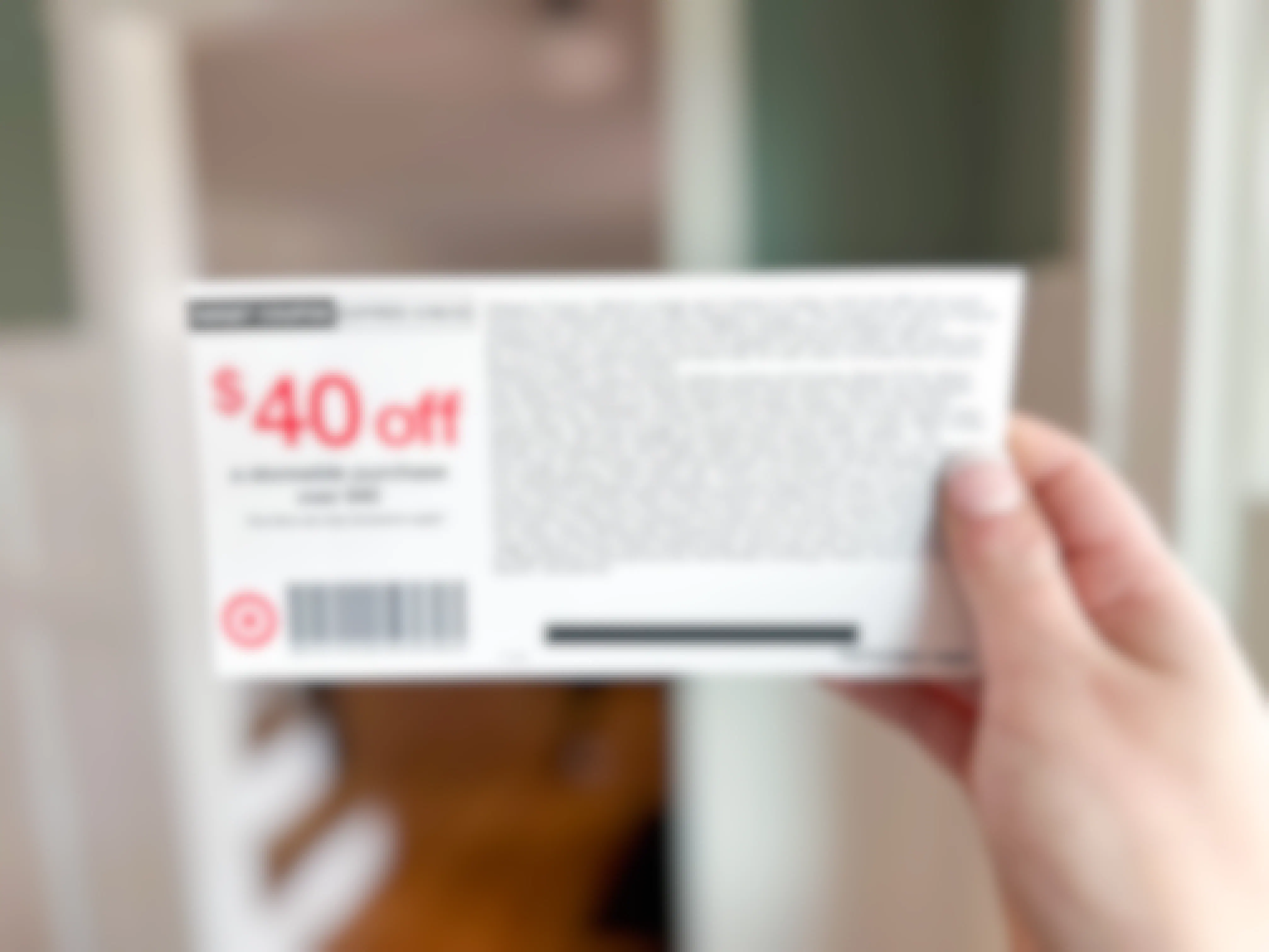 A woman's hand holding up a $40 off coupon from the limited-time Target RedCard offer for new members