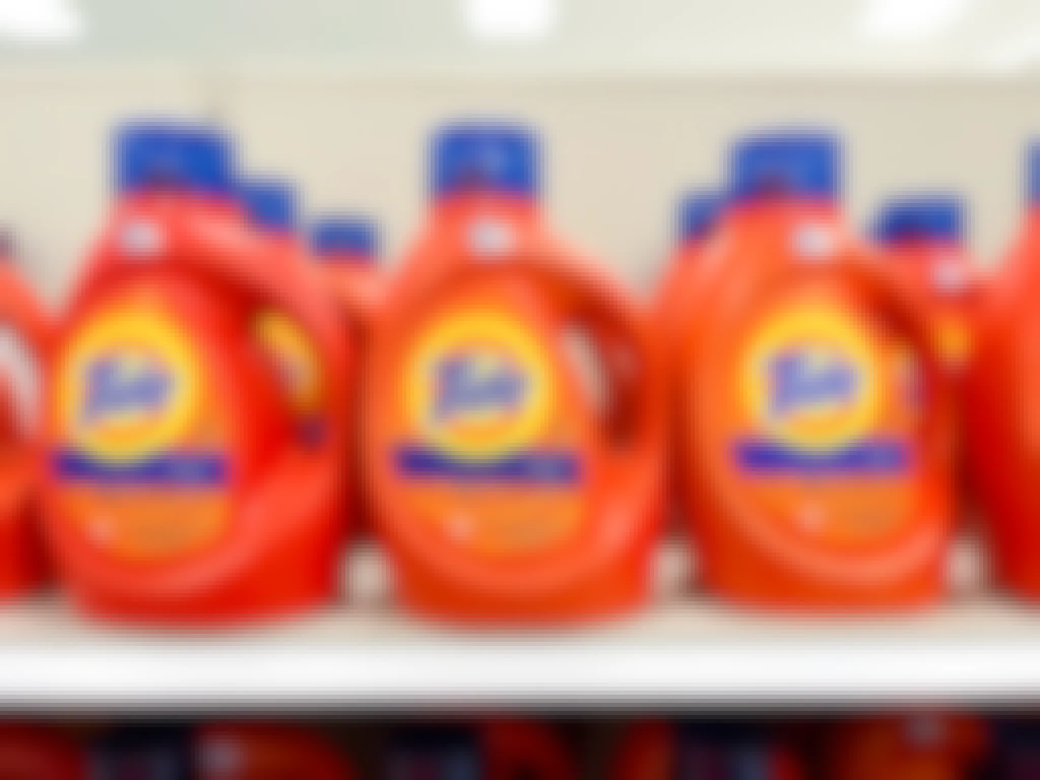 Bottles of Tide laundry detergent sitting on a shelf.