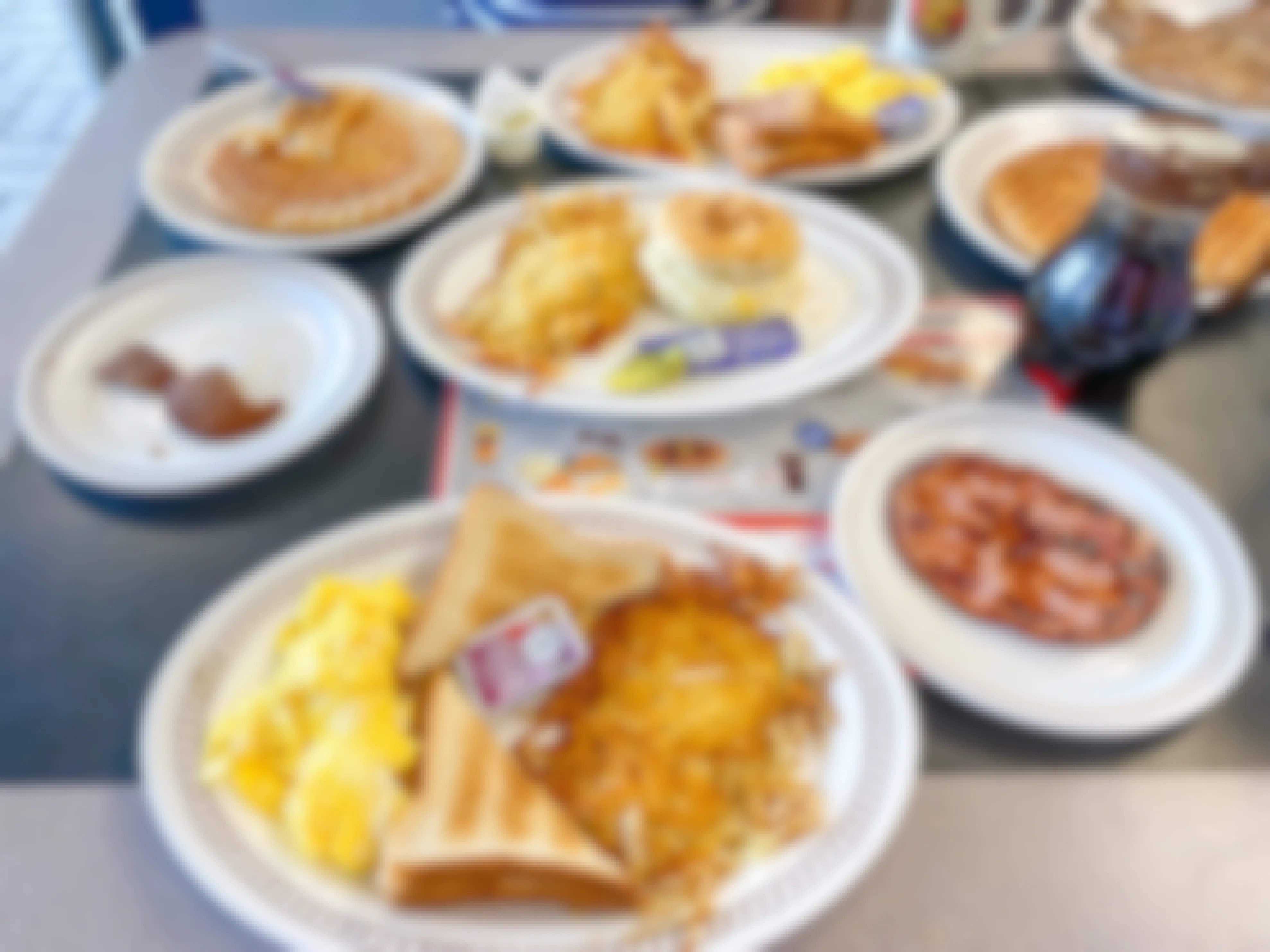A Waffle House table covered in plates of breakfast food.
