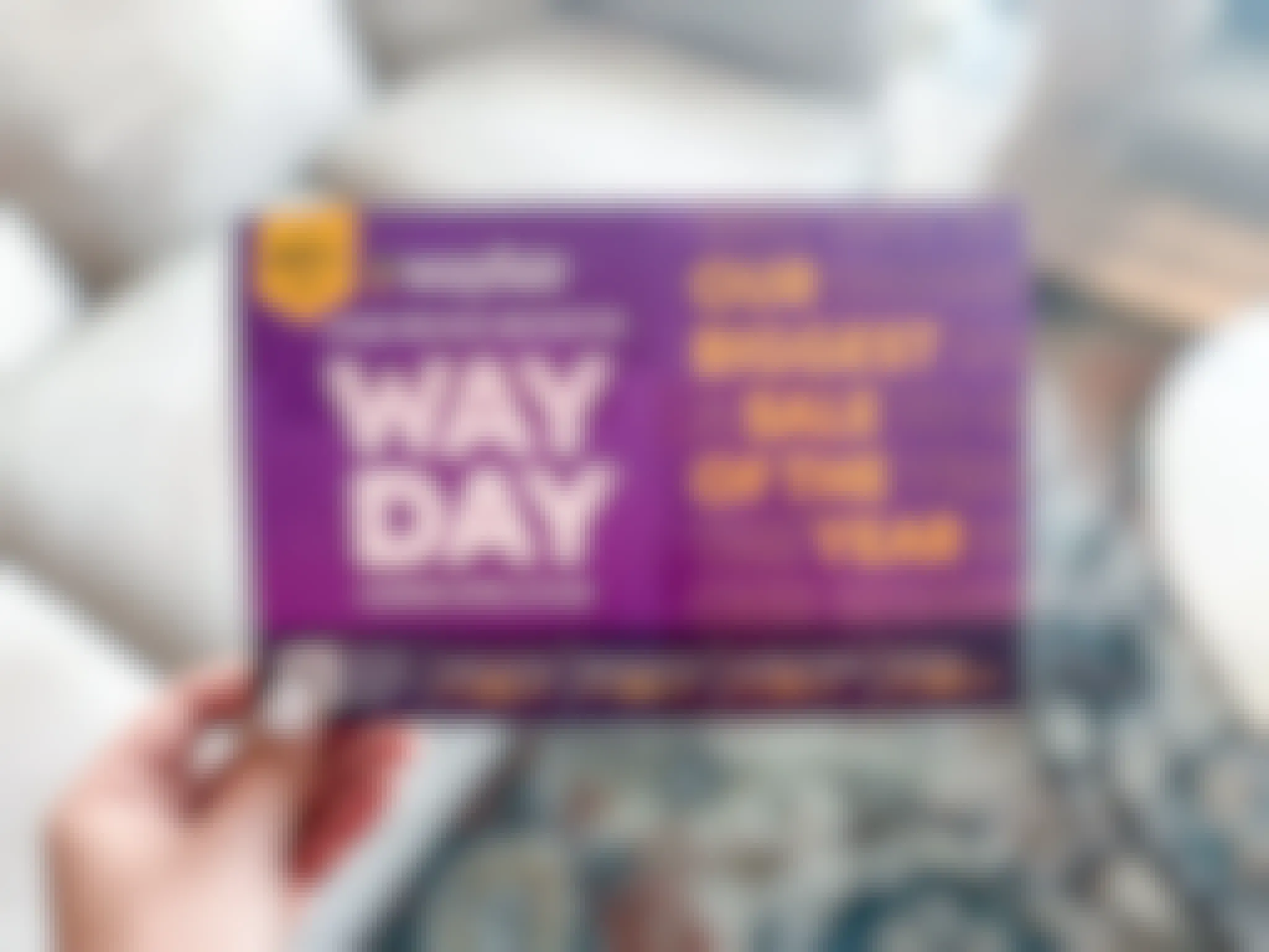 hand holding a private invitation mail flyer for the Wayfair Way Day sale event