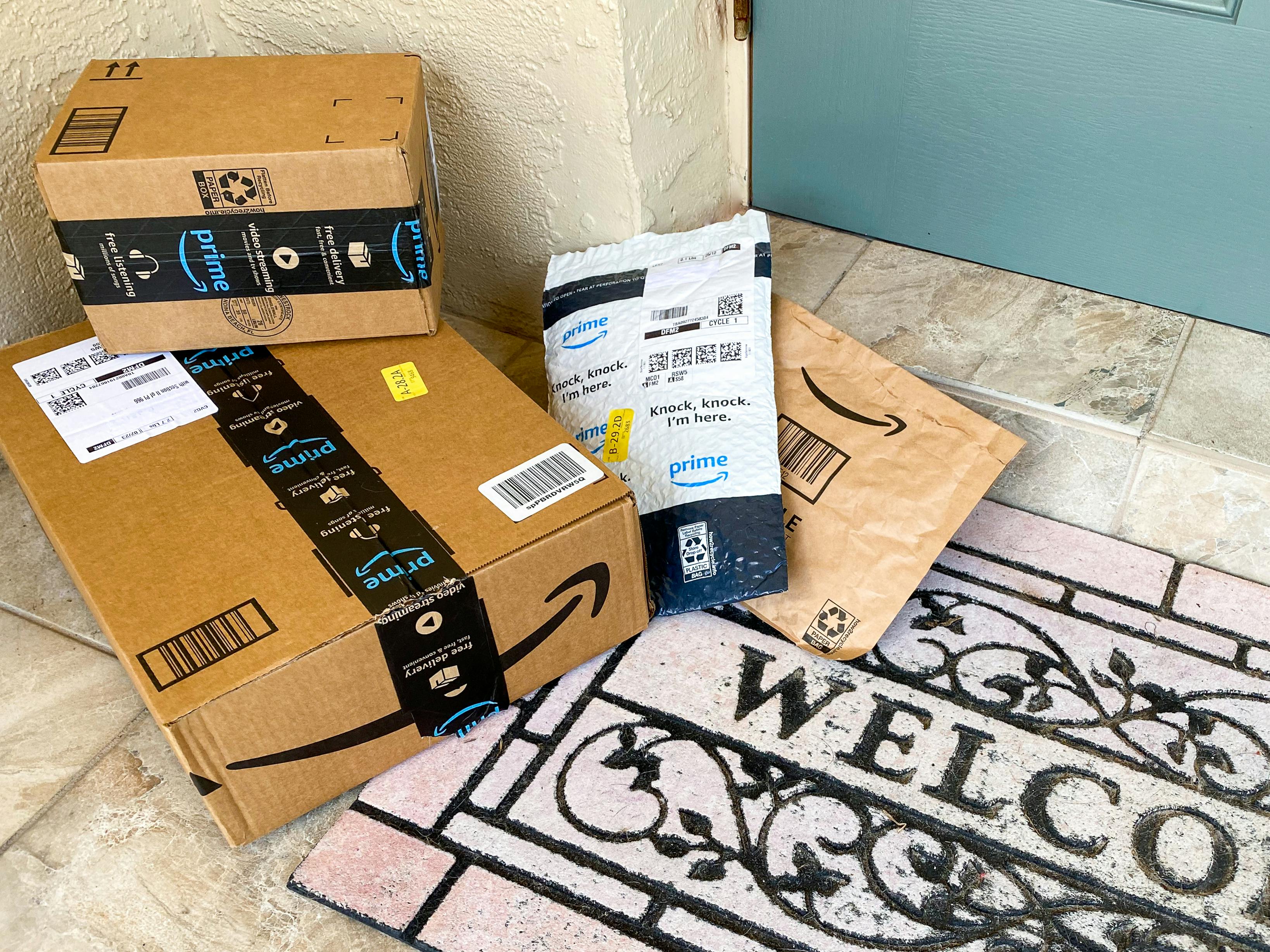 Amazon boxes sitting next to a doorstep.