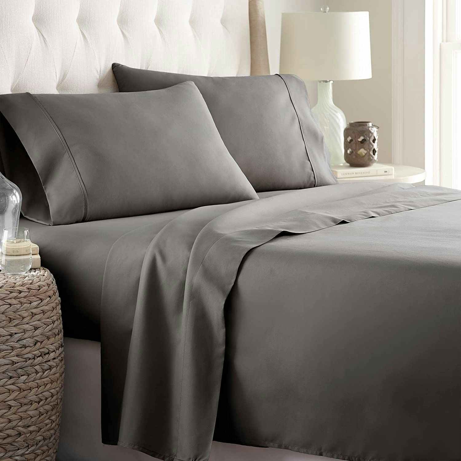 A bed with gray sheets.