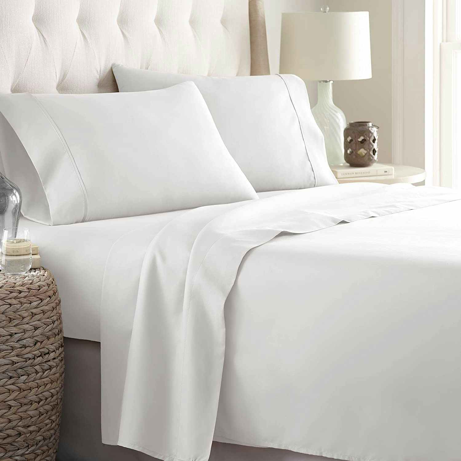 A white bed sheet set on a bed.