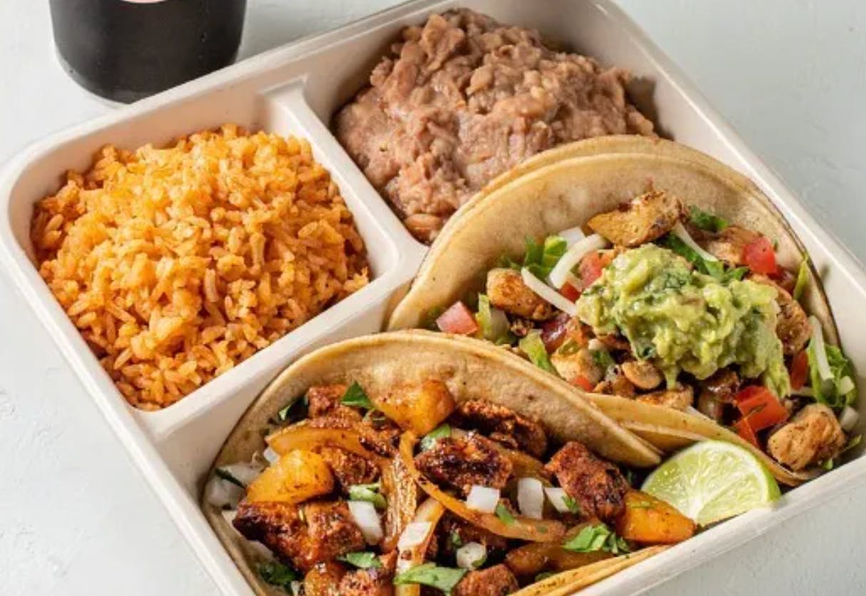 A taco plate from Chronic Tacos with two tacos, rice, and beans.