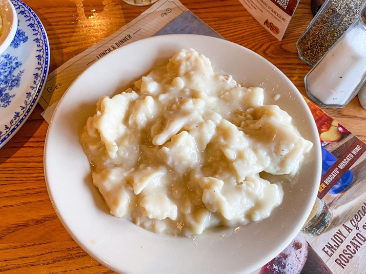 A plate of Cracker Barrel's Chicken n' Dumplings served on a table.