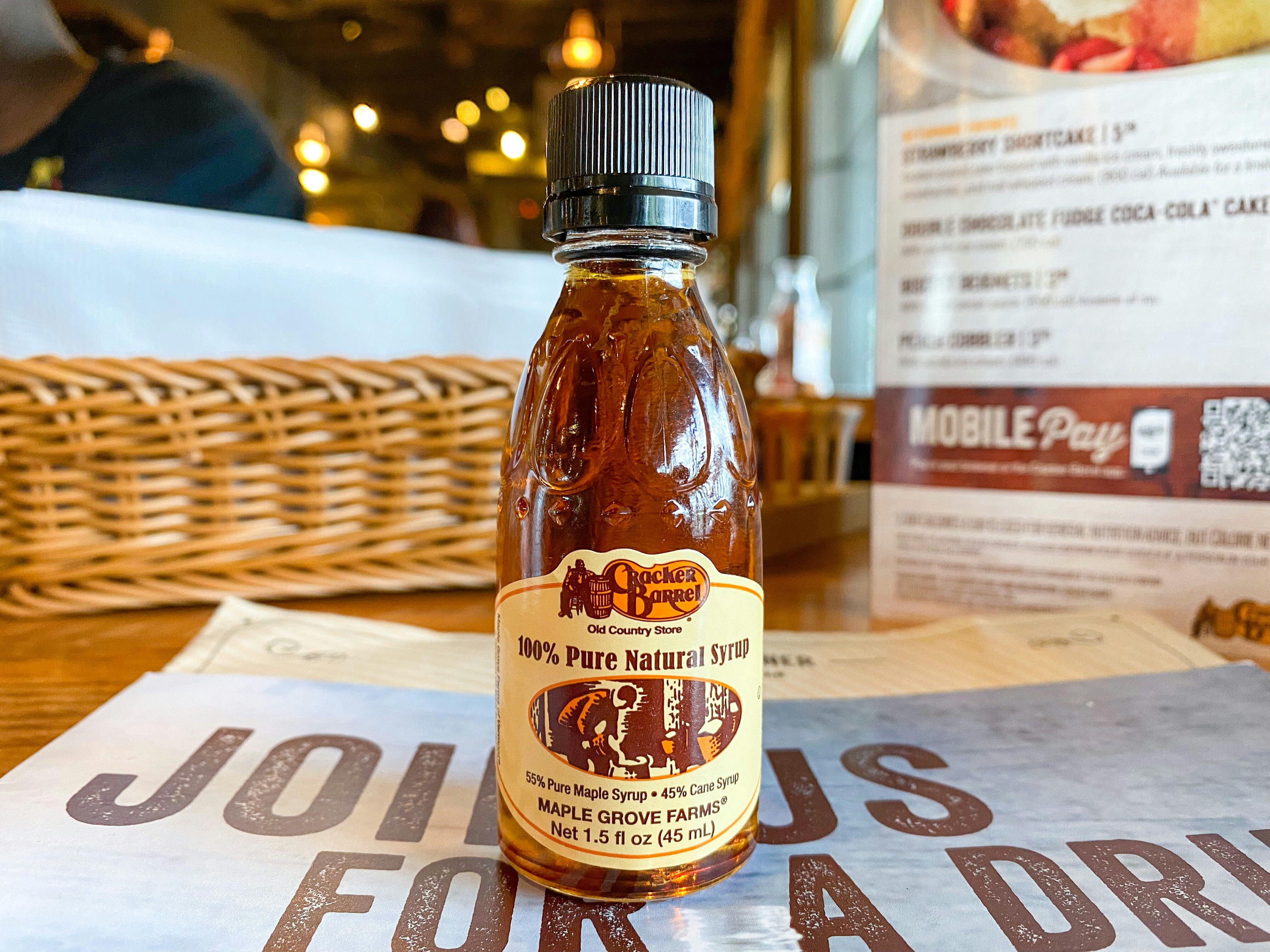 A small Cracker Barrel syrup bottle sitting on a table at Cracker Barrel.