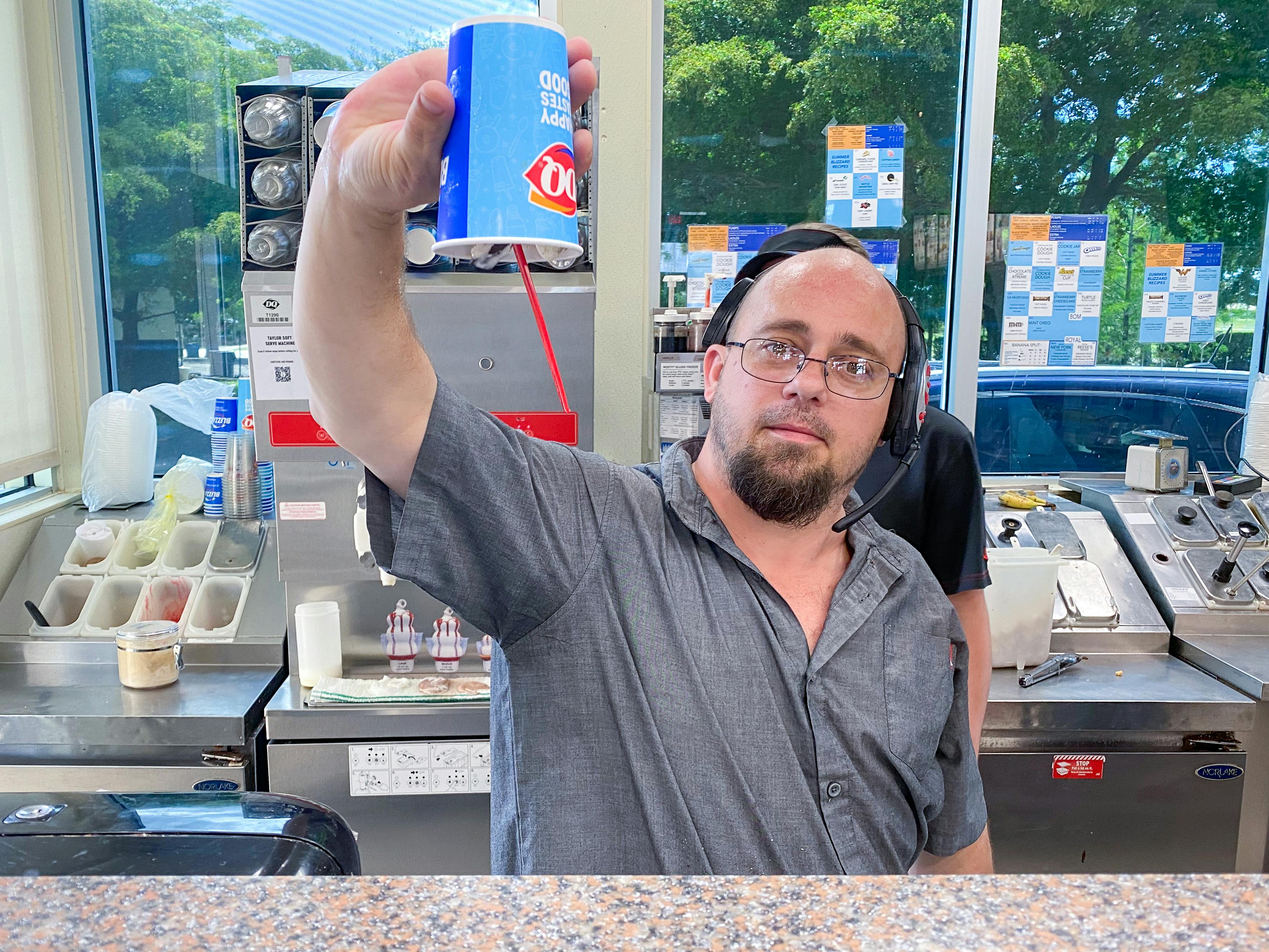 A Dairy Queen employee turning a Blizzard upside-down before serving it.