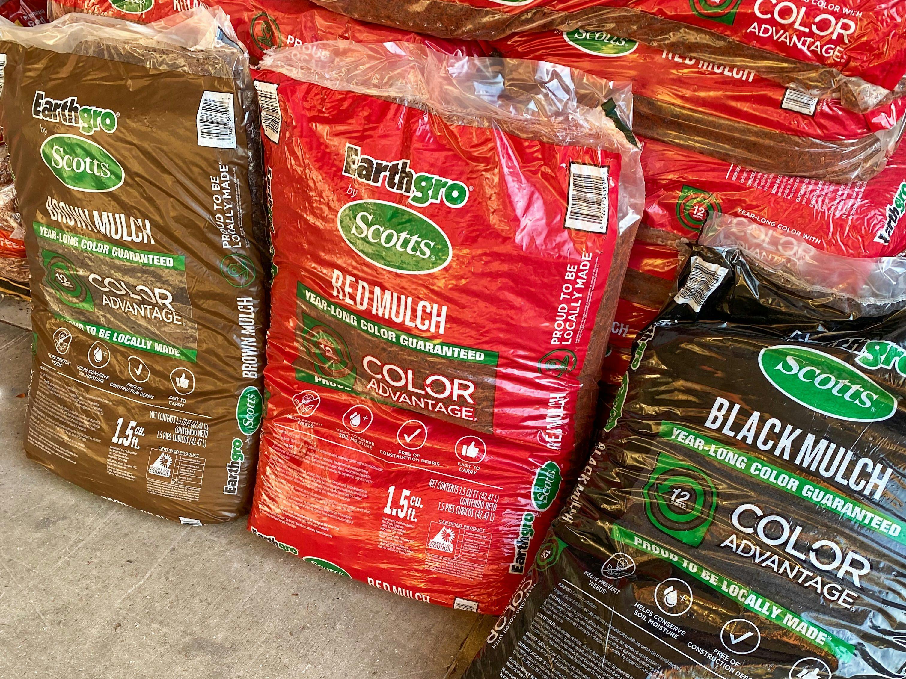 Three bags of earthgrow mulch at home depot, all of them are different colors - one brown, red, and black