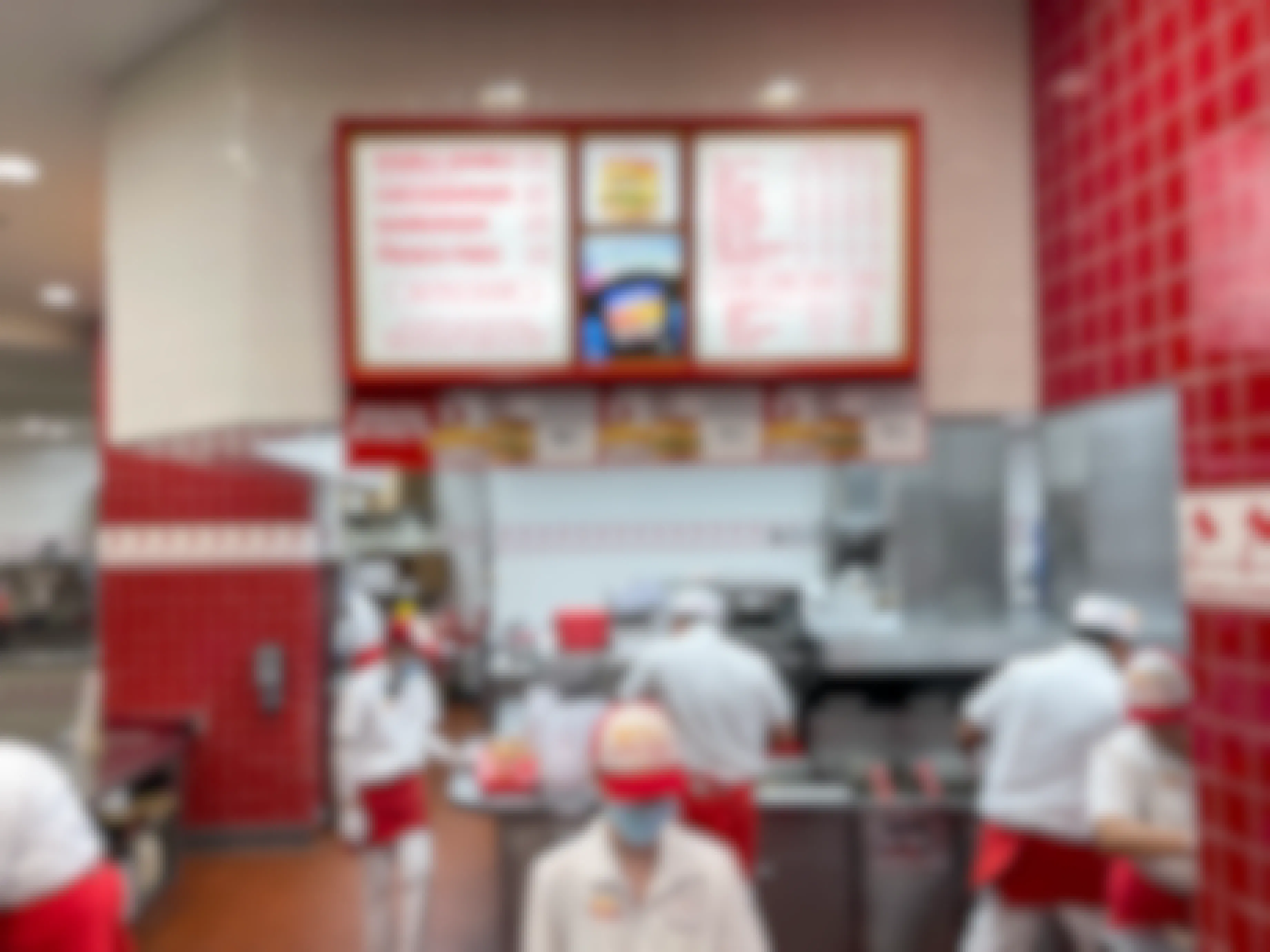 The ordering counter at In-N-Out burger with employees working in the kitchen.