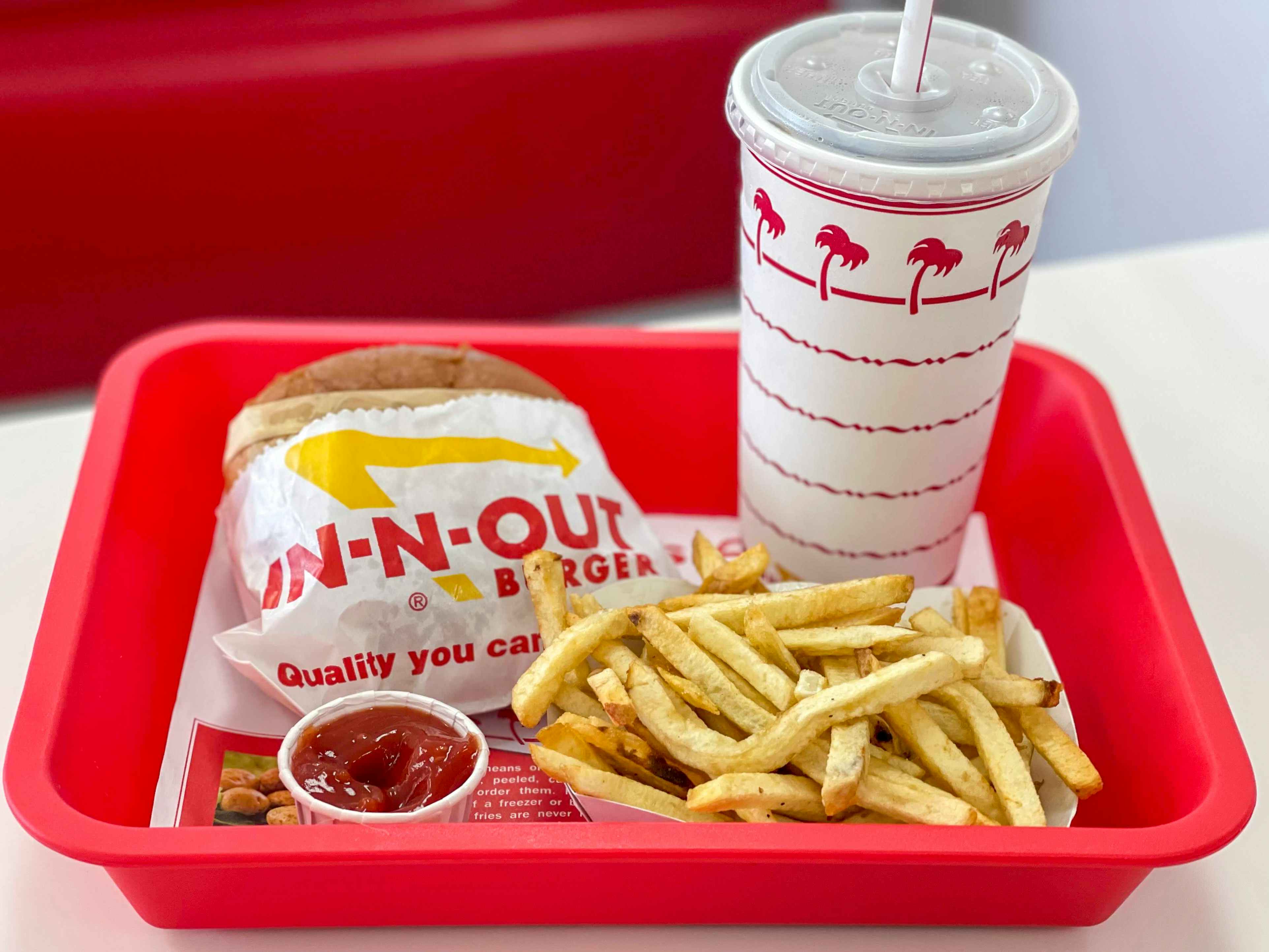 A combo meal with burger, drink, and fries on a red plastic tray at In-N-Out.