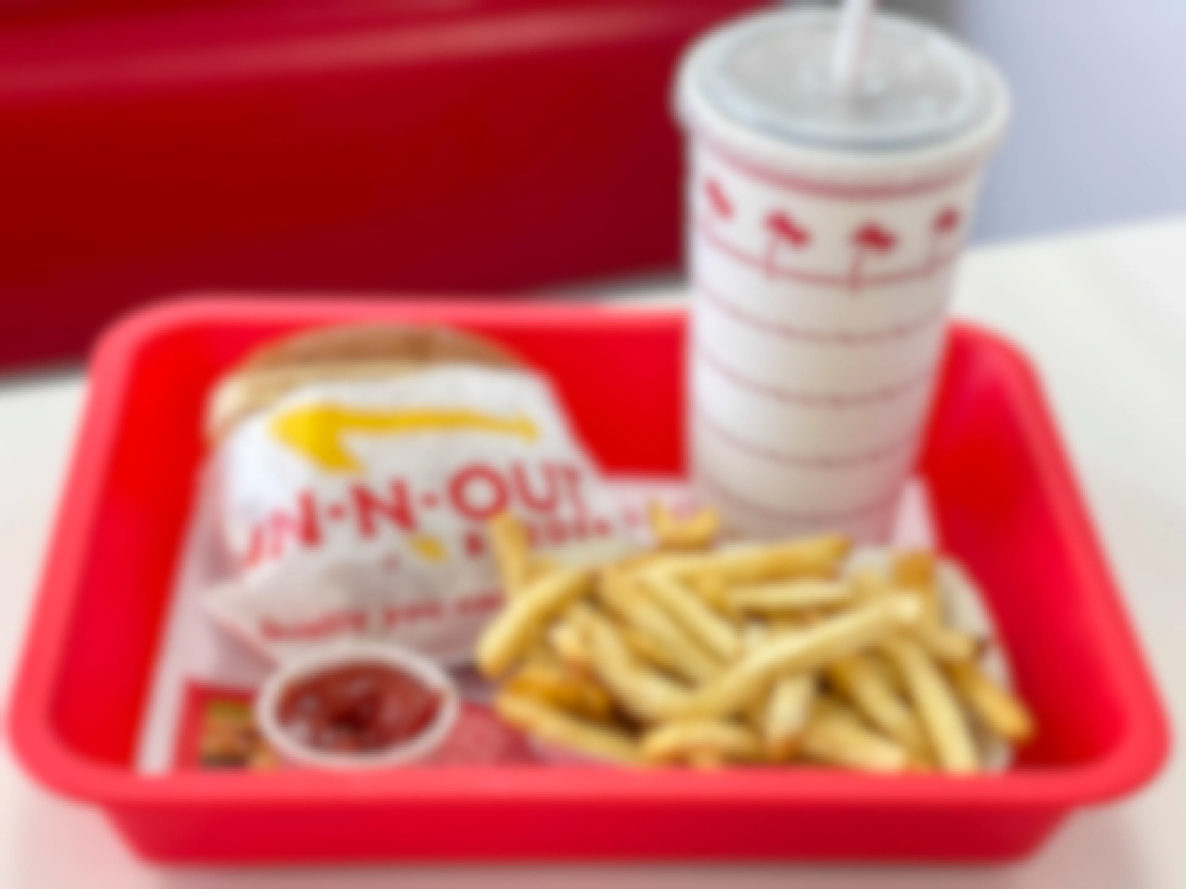 A combo meal with burger, drink, and fries on a red plastic tray at In-N-Out.