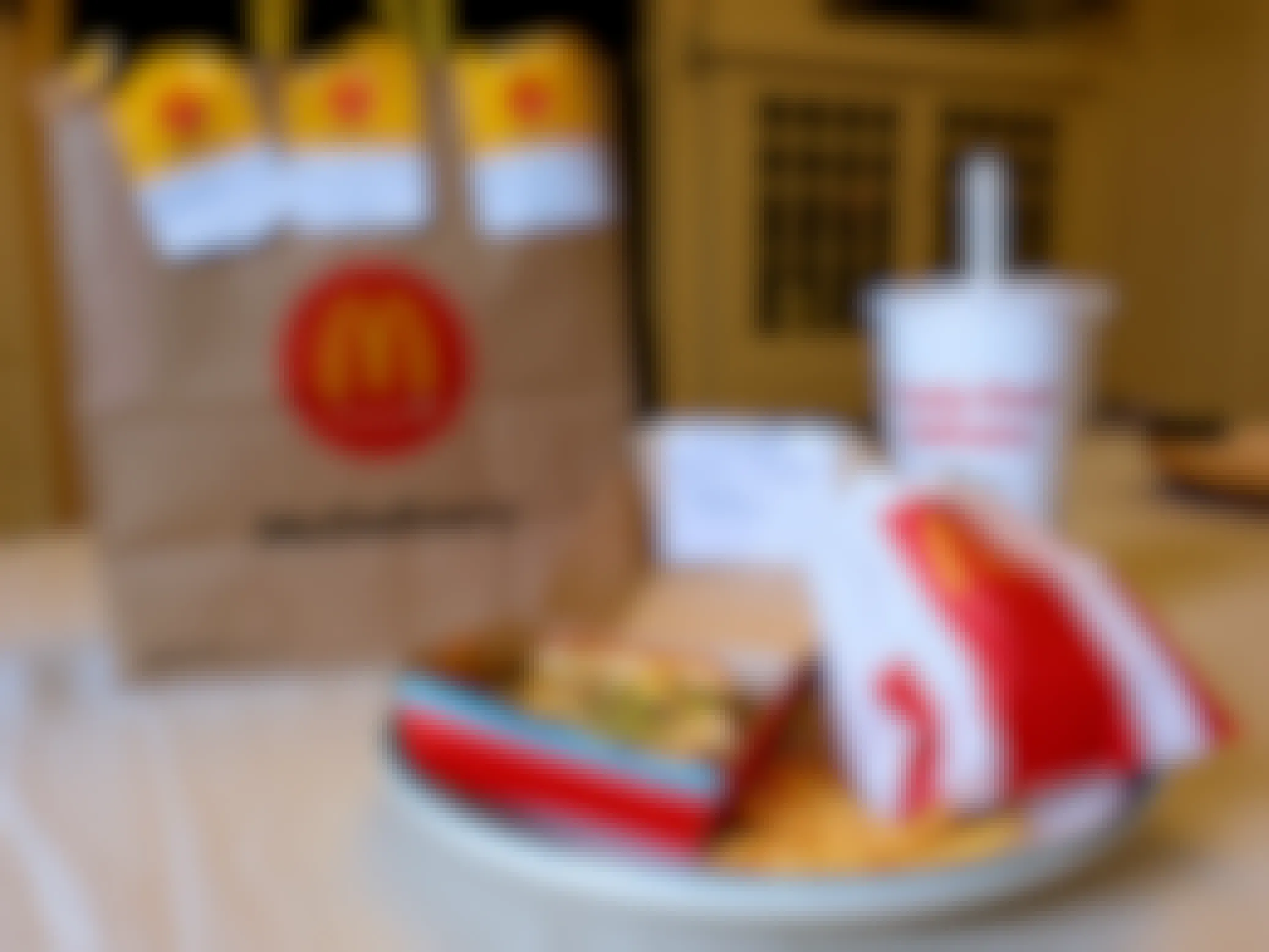 A Big Mac meal with fries and a drink sitting on a table next to a McDonald's McDelivery bag from Uber Eats.