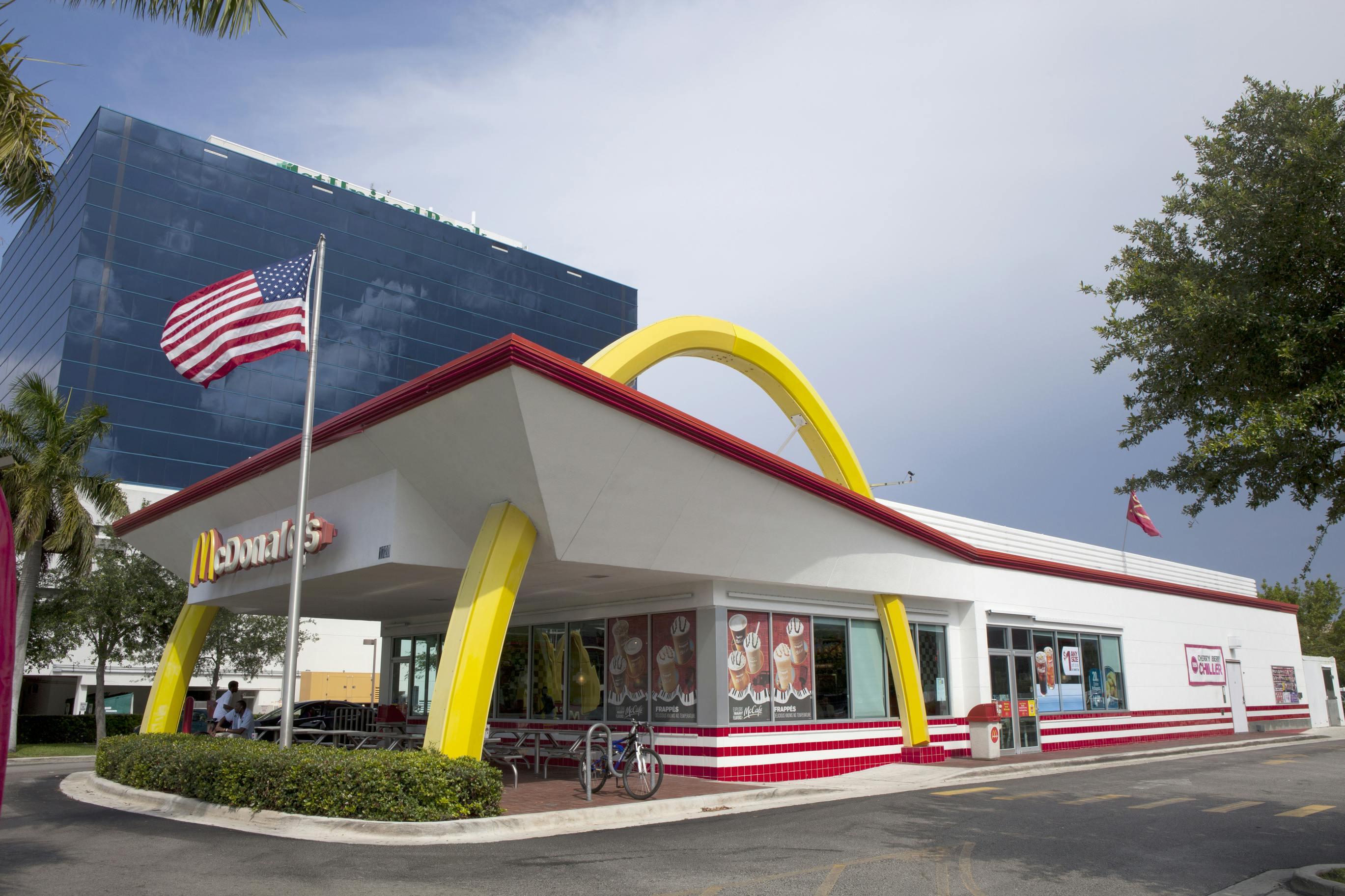 Exterior view of a McDonald's restaurant with an American flag out front.