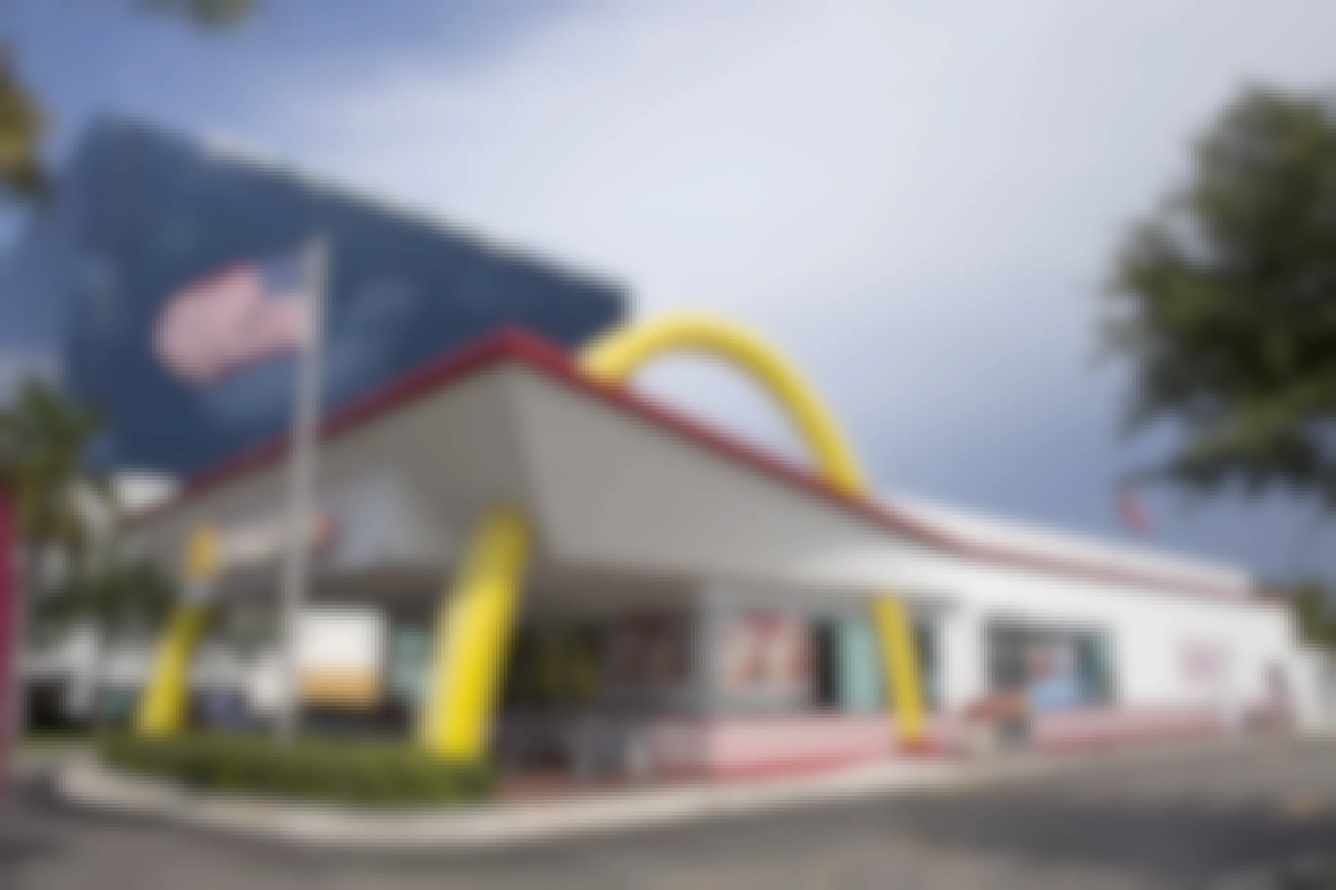 Exterior view of a McDonald's restaurant with an American flag out front.