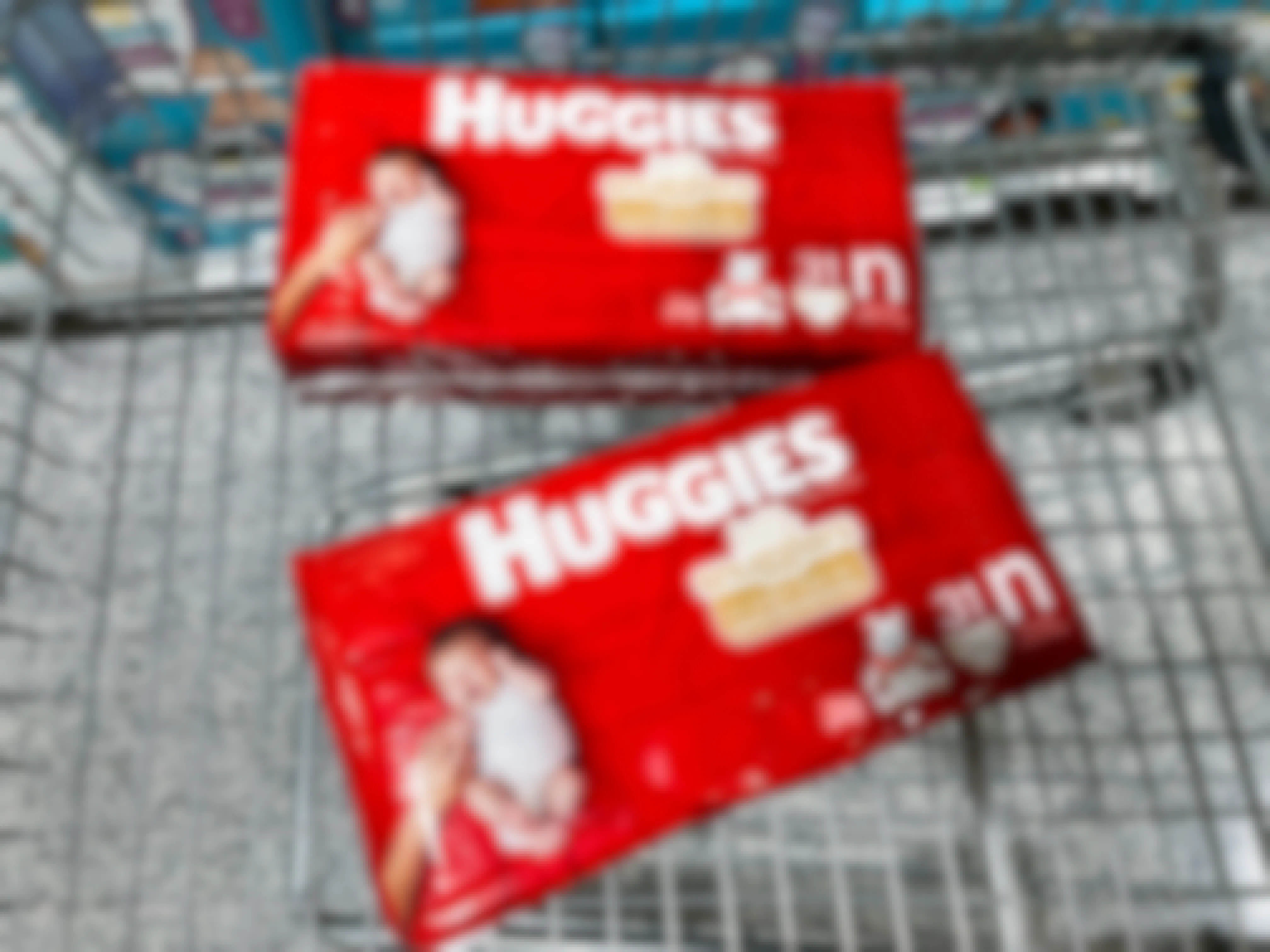 Two packs of newborn Huggies diapers in a grocery cart.