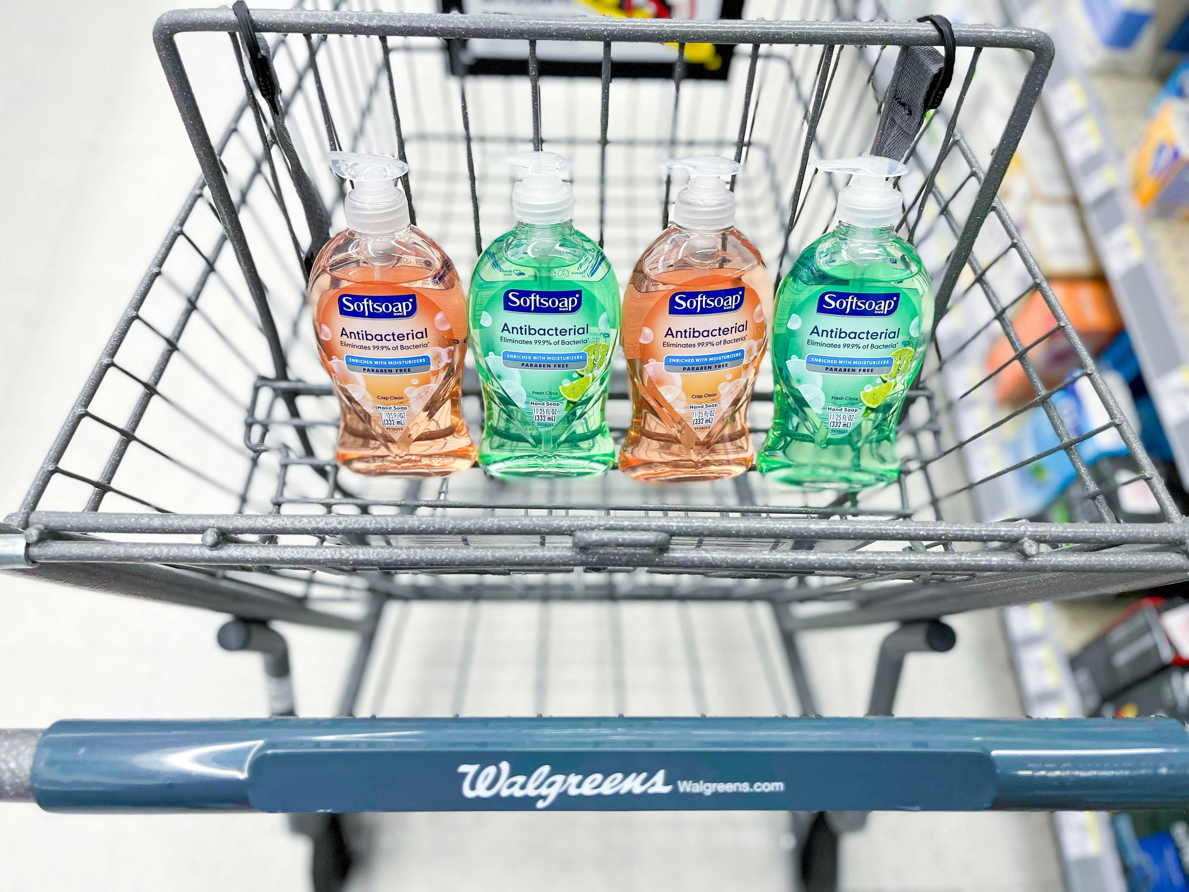four bottles of Softsoap hand soap sitting in the basket portion of a Walgreens cart