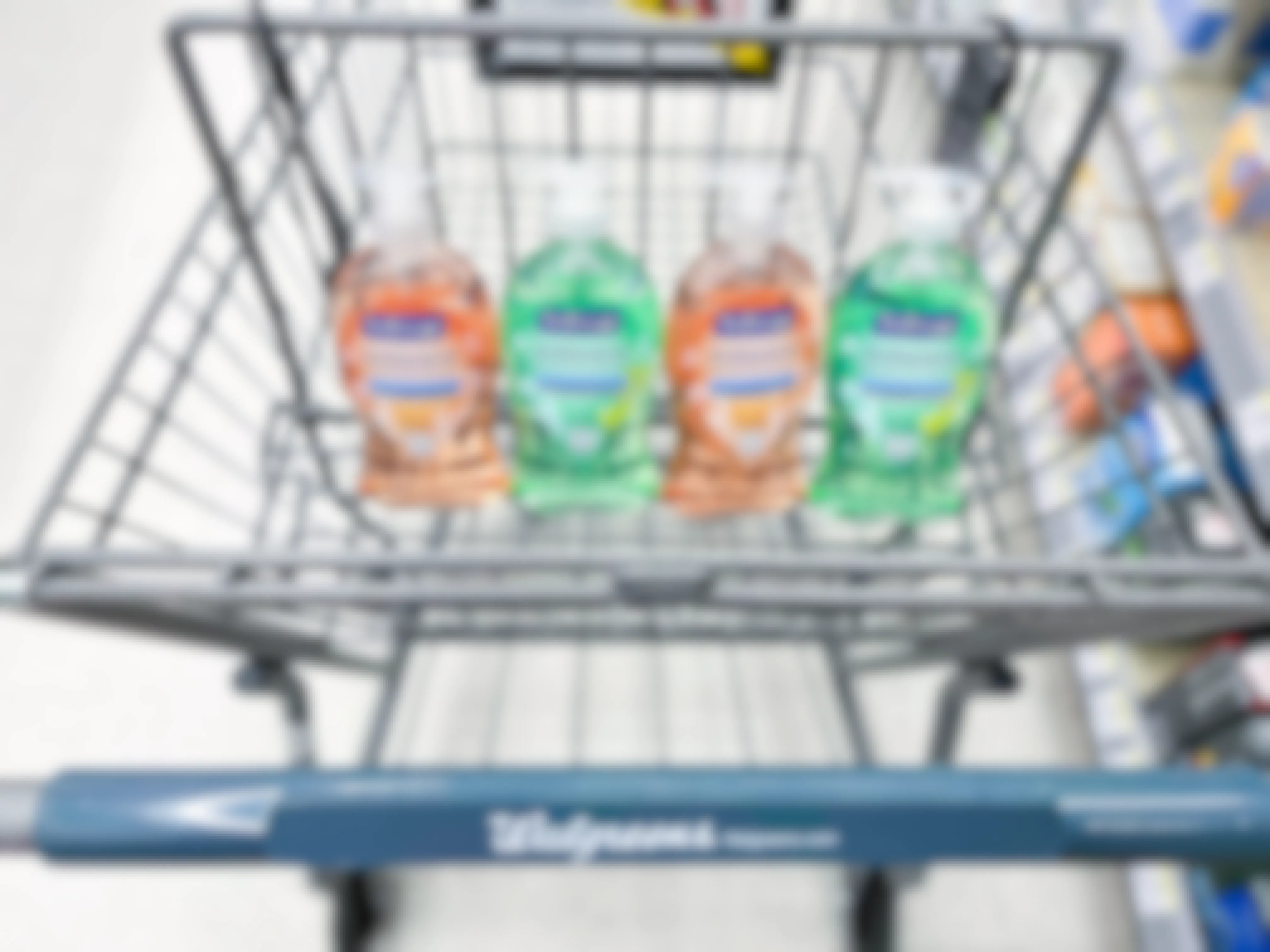 four bottles of Softsoap hand soap sitting in the basket portion of a Walgreens cart