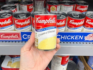 Someone holding a can of Campbell's chicken noodle soup in Walmart