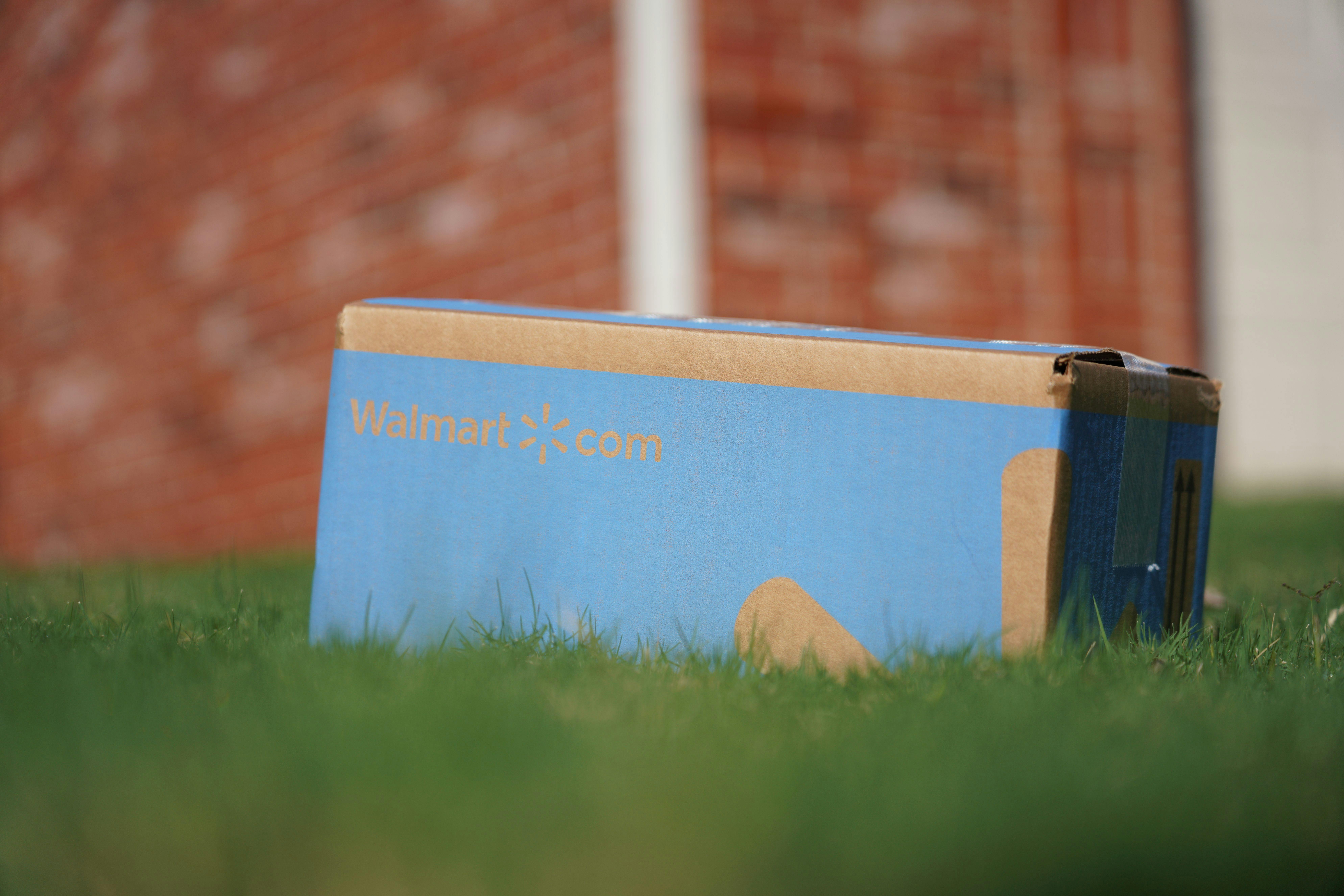 A Walmart drone delivery package sitting in some grass.
