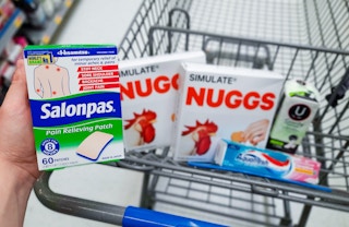 Salonpas Patches held over Walmart shopping cart filled with Simulate Nuggs, Aquafresh Toothpaste, and U by Kotex Liners