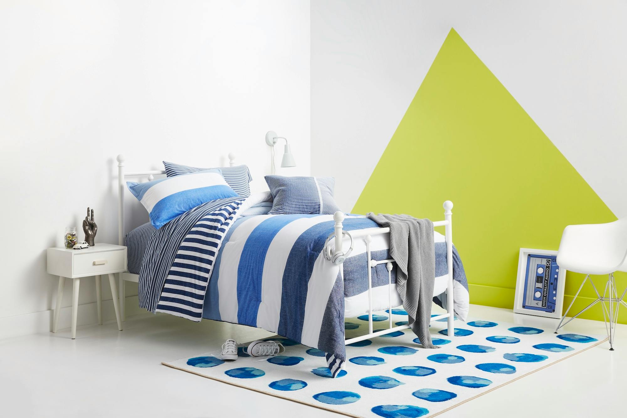 A Gap Kids Home set with a made bed, nightstand, rug, and chair.