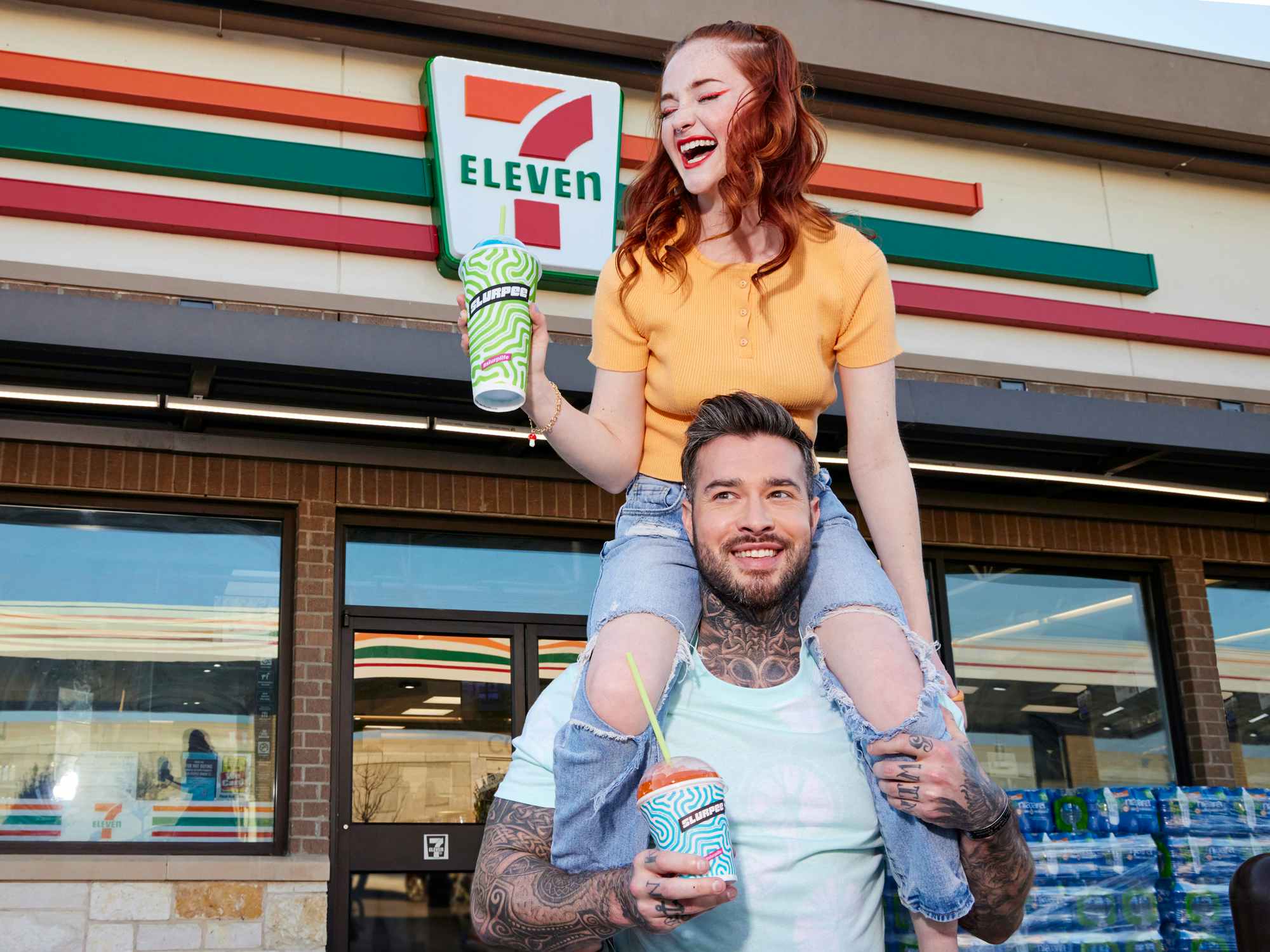 two people with slurpees in front of 7-eleven entrance