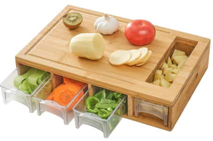 A cutting board with food prep trays inside
