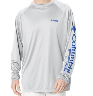 A guy modeling a grey t-shirt on a white background